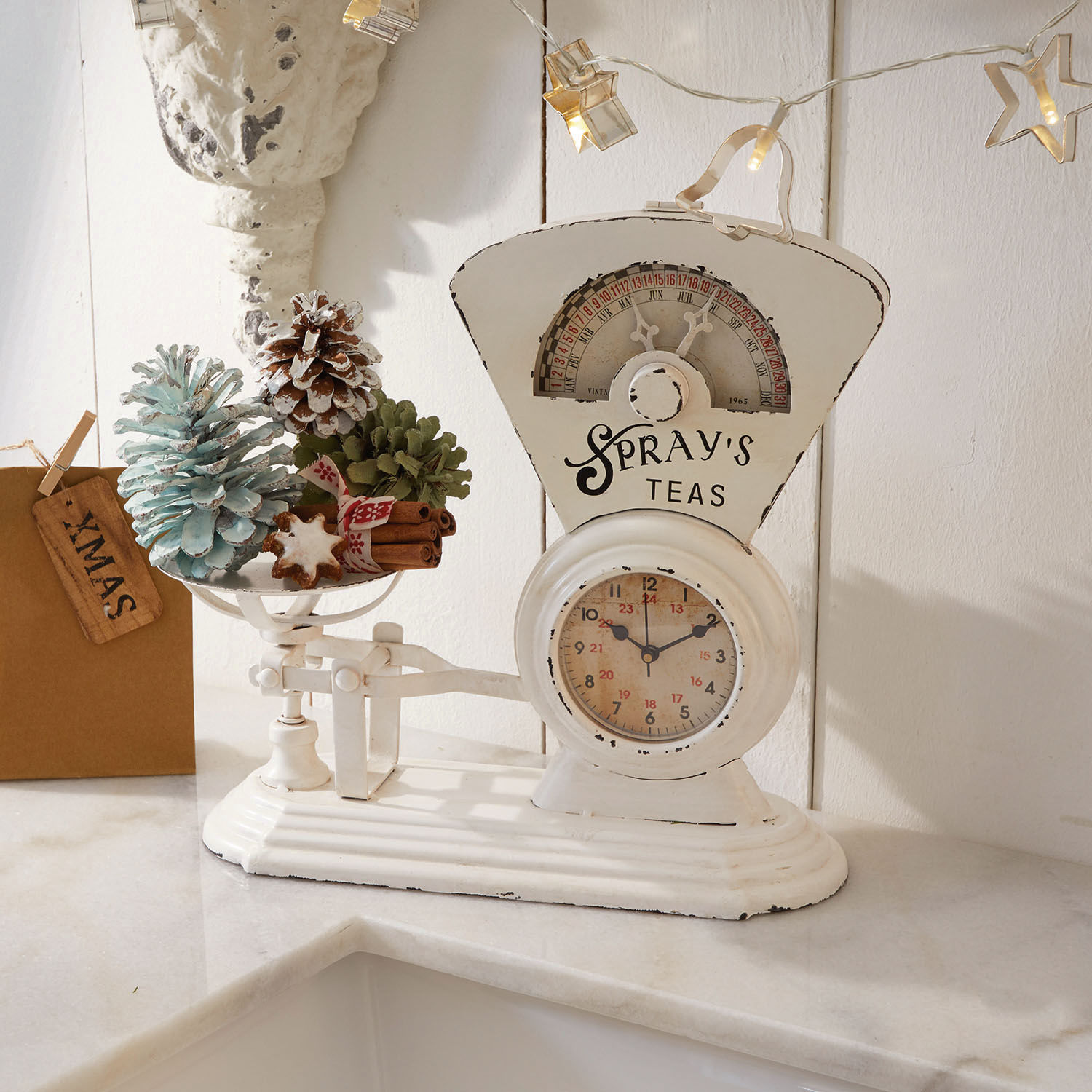 Horloge Balances Balance de cuisine blanche en métal avec décorations de Noël et pommes de pin sur un plan de travail