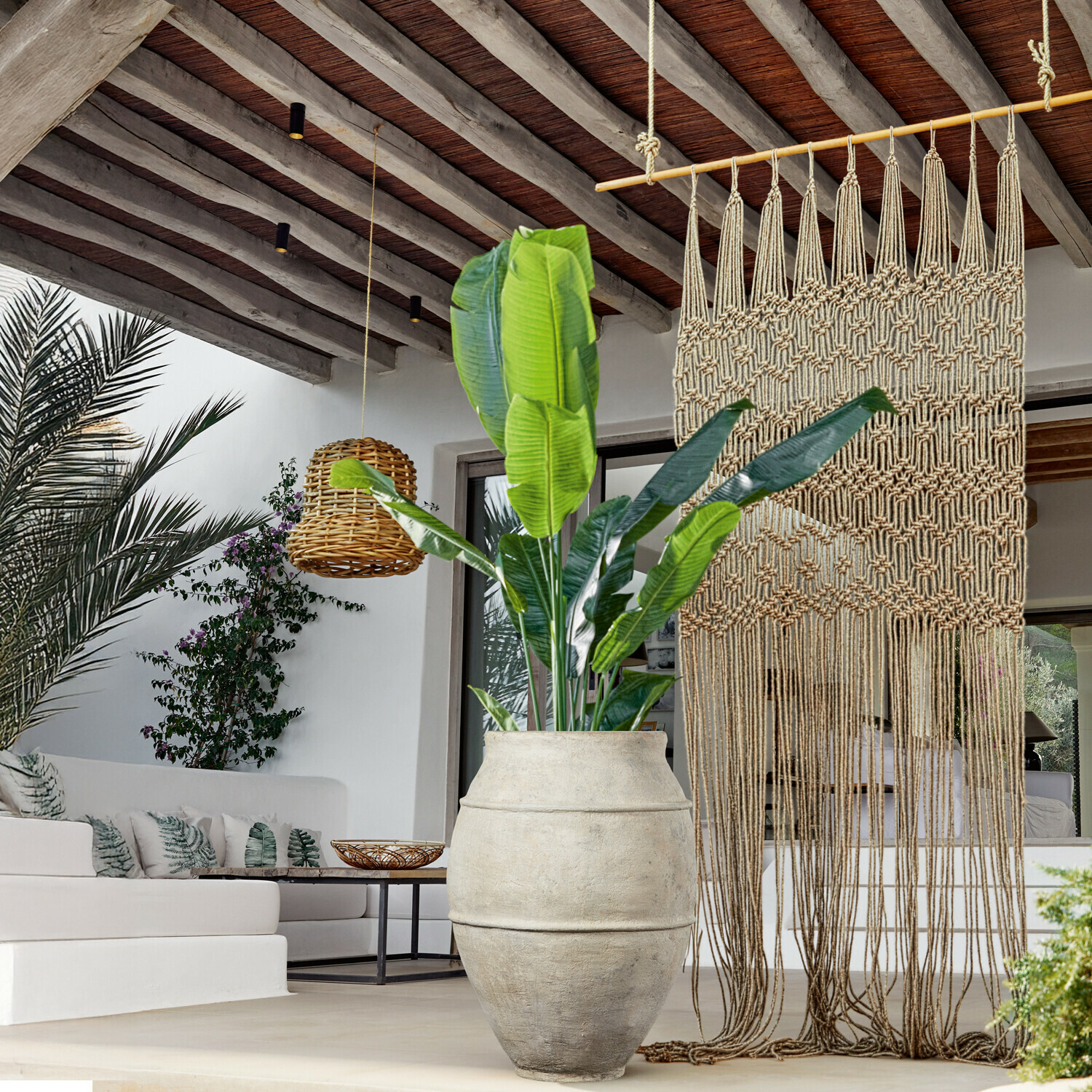 Sierplant Lennidas Grote lichte stenen pot met groene plant in moderne woonkamer met macramé en rotan lamp