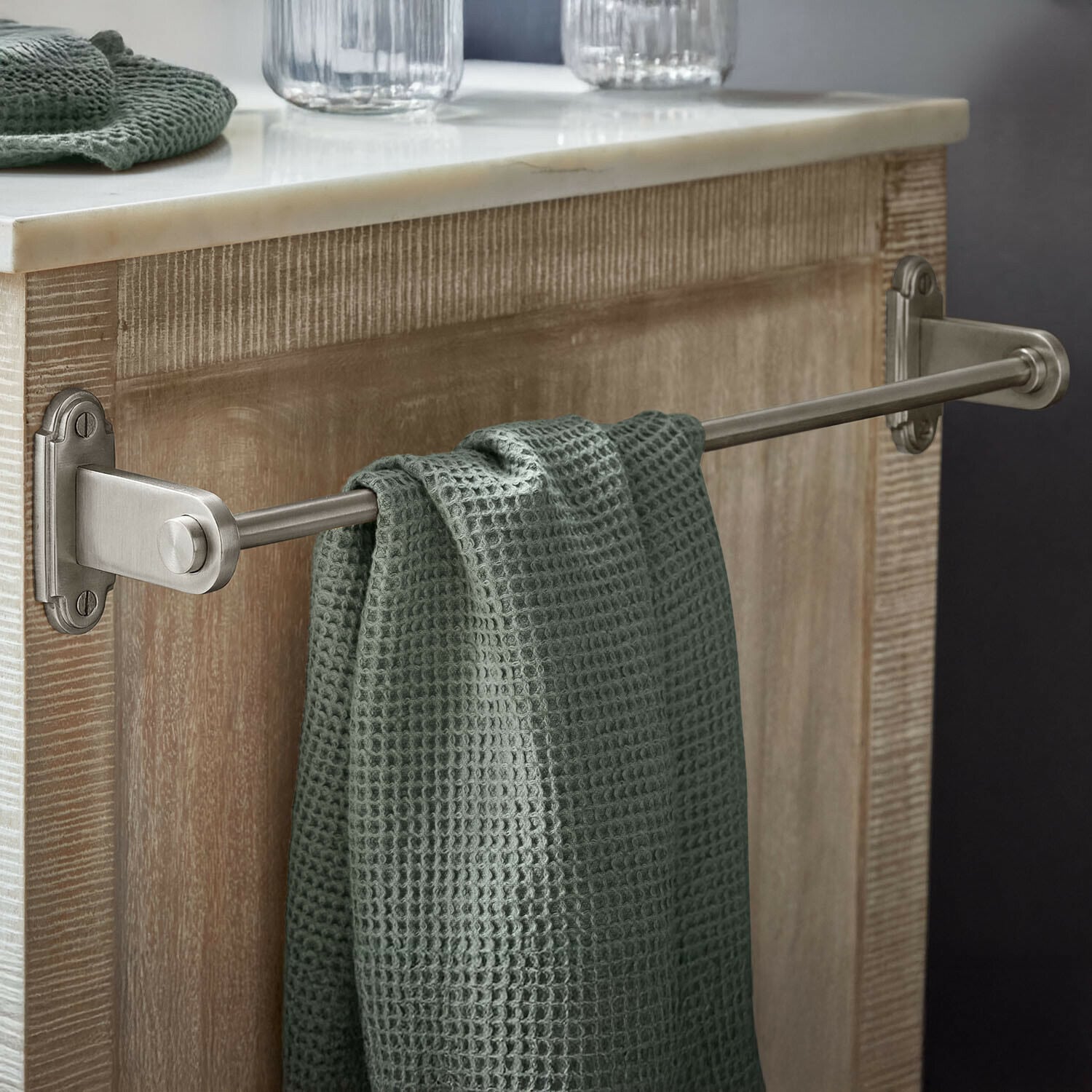 Porte-serviettes Virellane Porte-serviettes en métal avec serviette verte gaufrée suspendue sur un meuble en bois clair