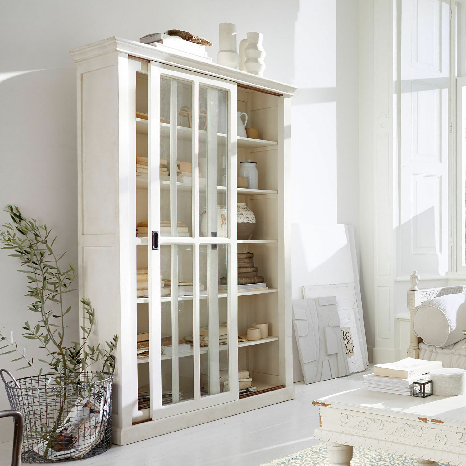 Vitrine Brouns Vitrine en bois blanc avec portes coulissantes en verre dans un salon lumineux et moderne