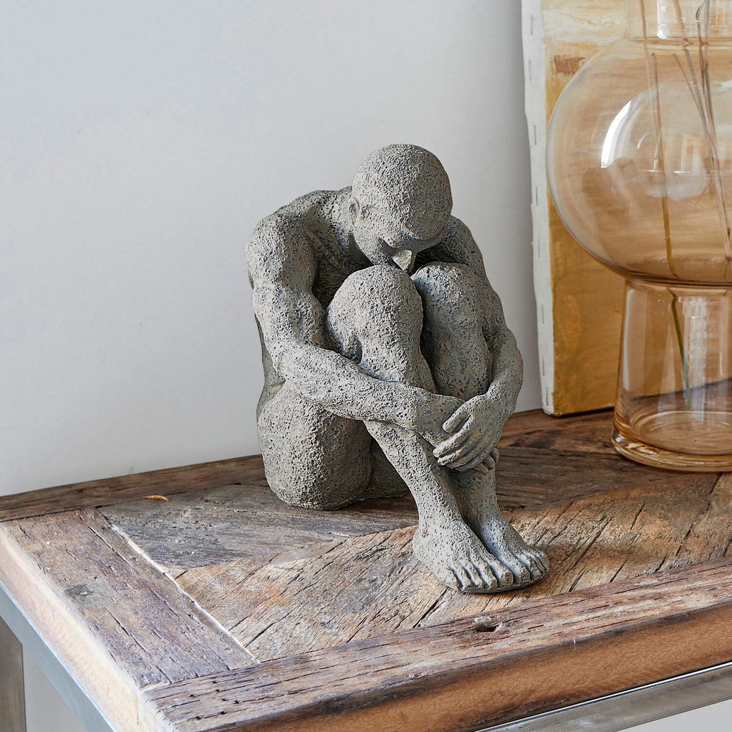 Statuette Antony Sculpture grise d'une figure assise sur une table en bois, décoration intérieure moderne