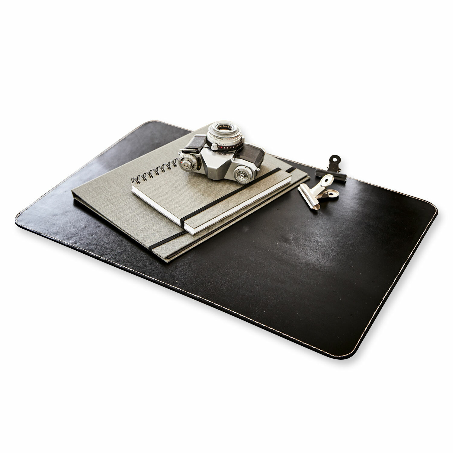 Sous-main Jansen Sous-main en cuir noir avec carnets gris et appareil photo argenté sur bureau moderne