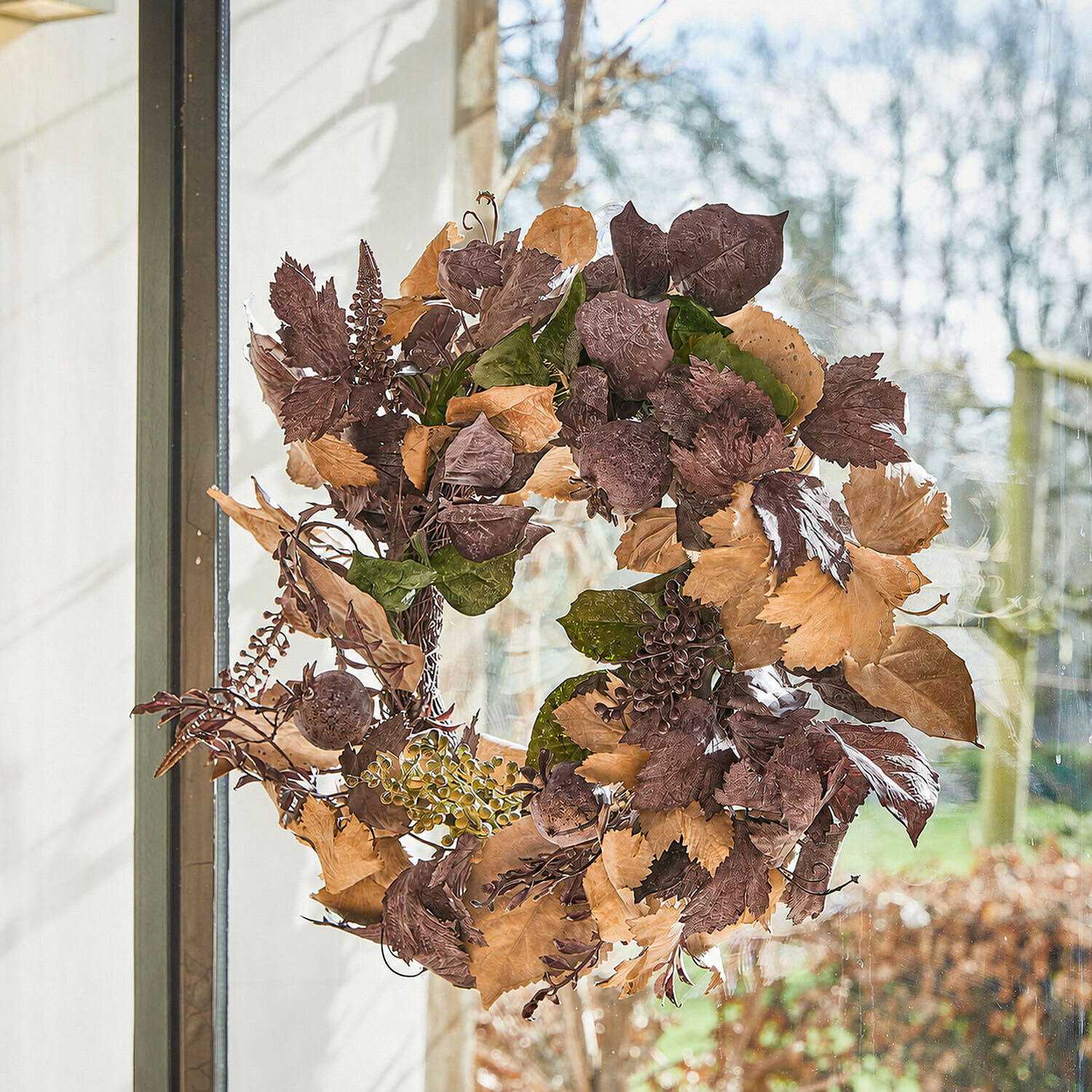 Krans Yvorie Eetkamer met ronde houten tafel en rotan stoelen met witte kussens en herfstdecoratie