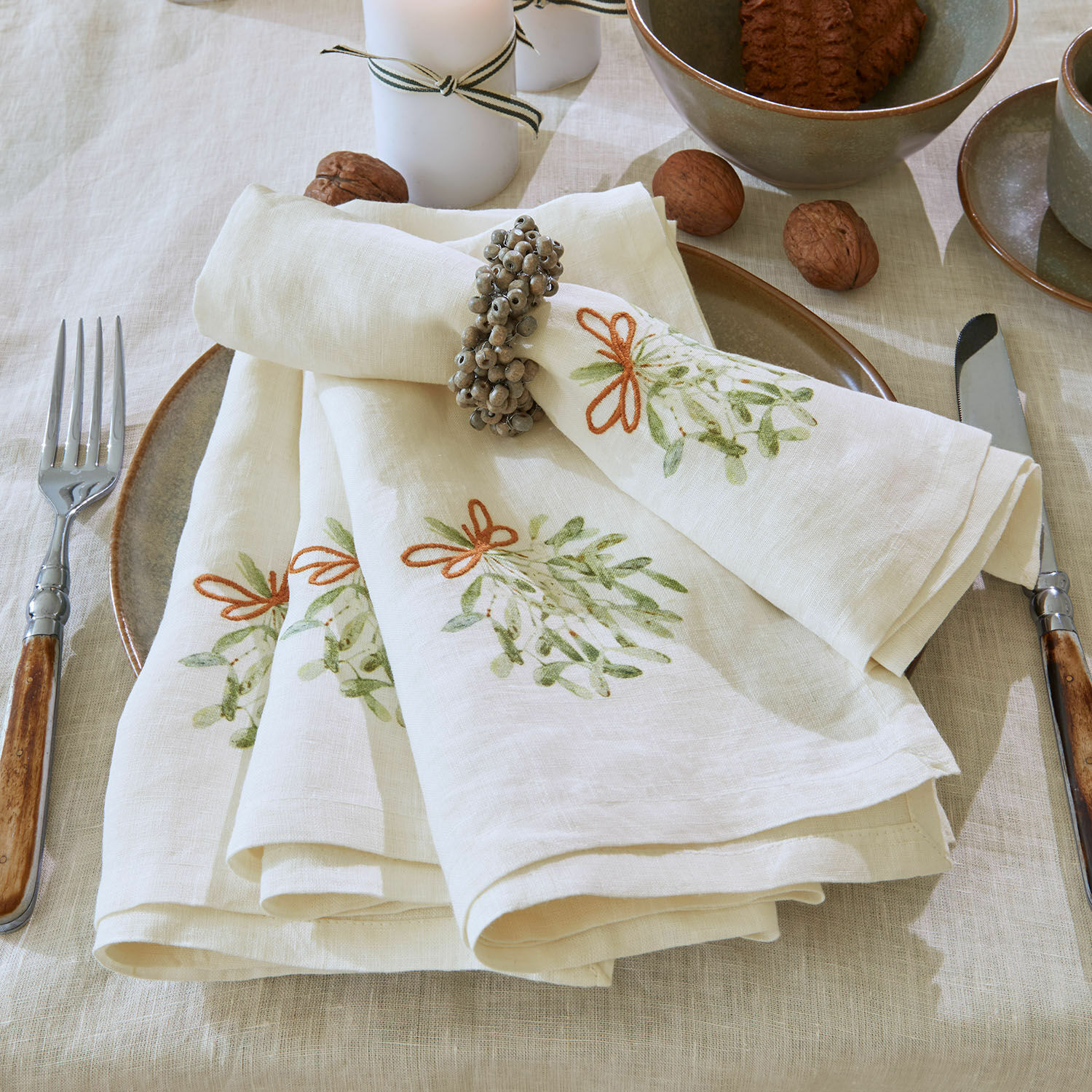 Servet set van 4 Mistletoe Crème linnen servetten met groen patroon en servetring op tafel met servies en walnoten