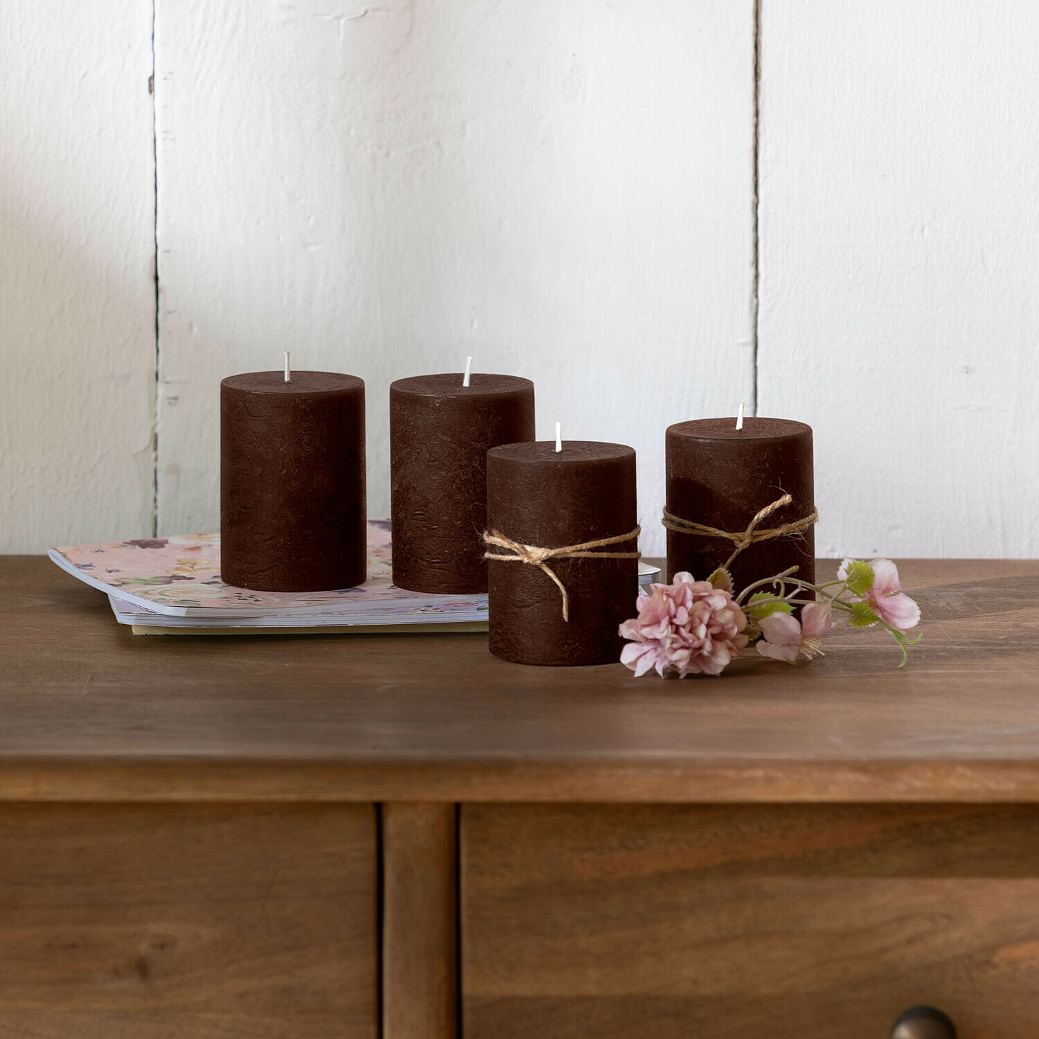 Kaars set van 4 Virrans Set van vier bruine decoratieve waskaarsen op houten tafel met bloemen als decoratie