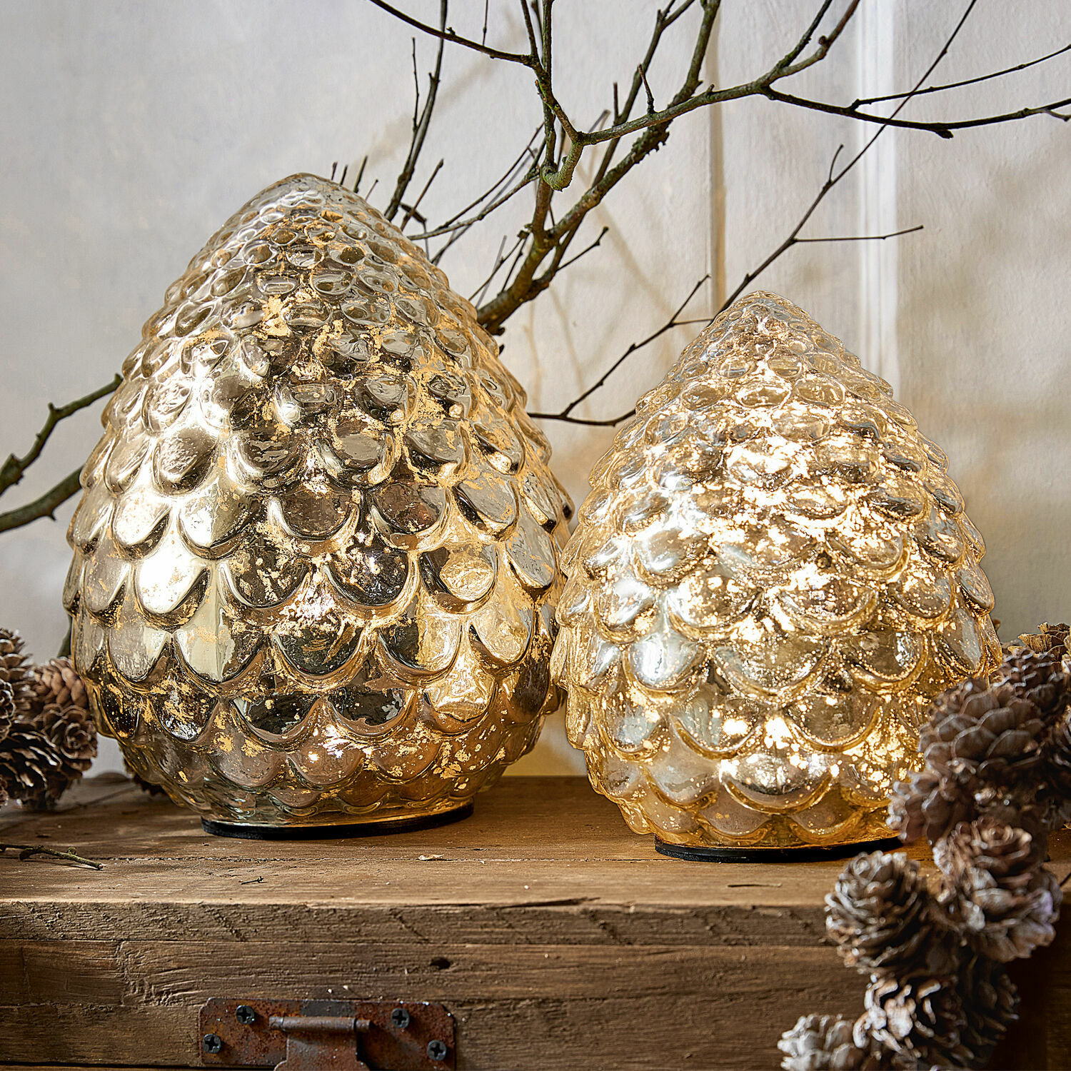 Led-dennenappel set van 2 Ibaque Twee gouden decoratieve glazen kegels met schubbenstructuur op houten blad met dennenappels