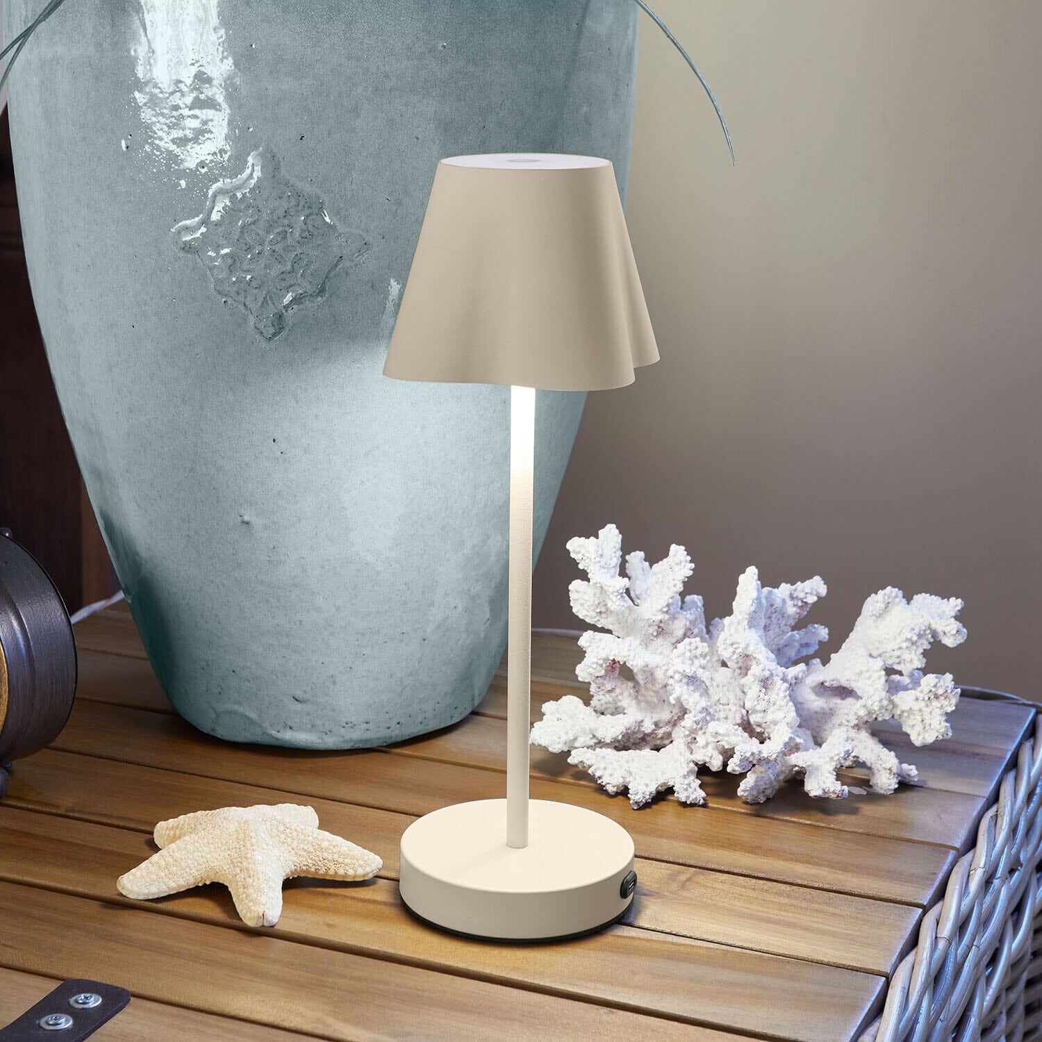 Oplaadbare tafellamp Tenari Beige metalen tafellamp op houten tafel met maritieme decoratie en grote vaas