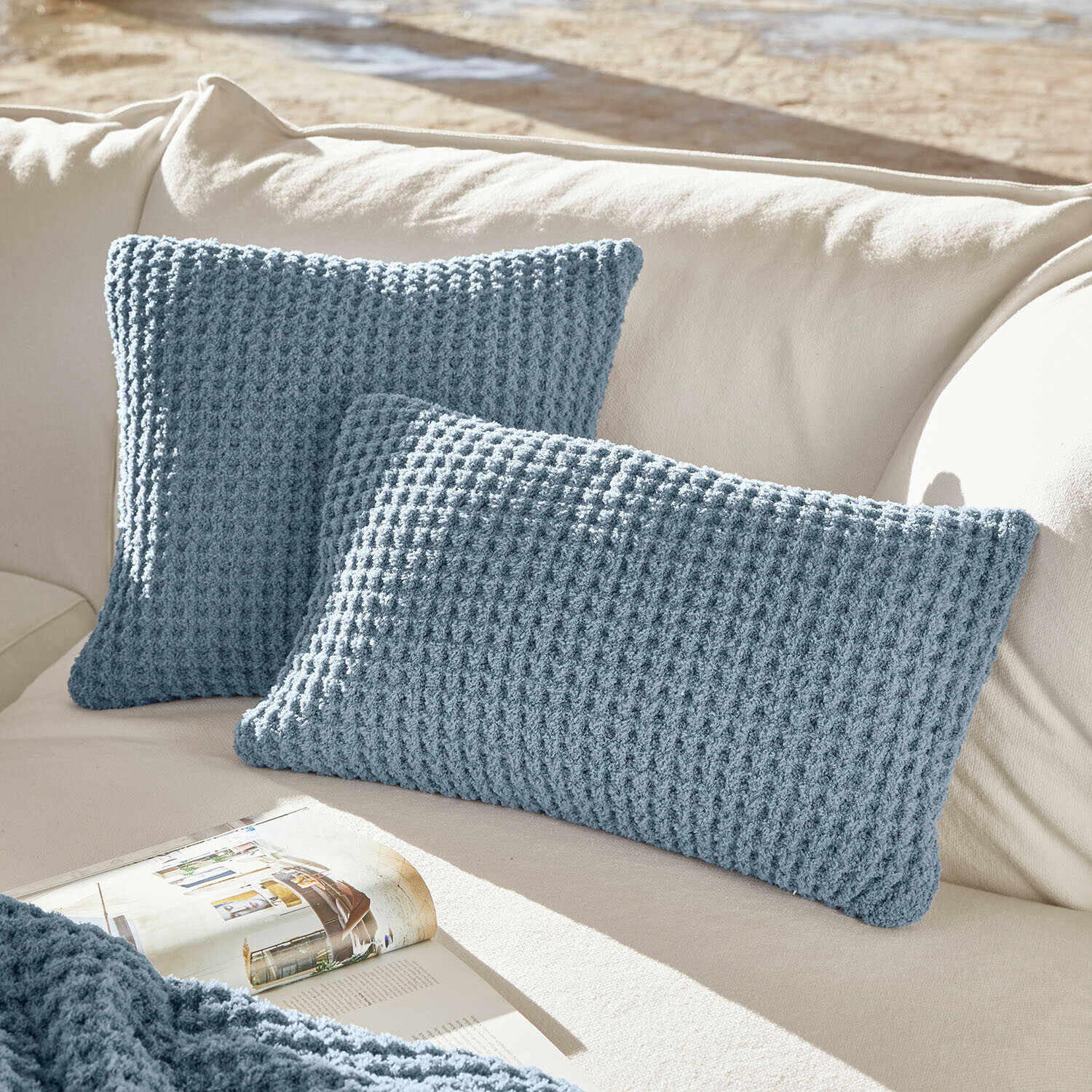 Lot de 2 housses de coussins Ysilda Coussins bleus en tricot sur canapé crème, décorations douces pour salon confortable