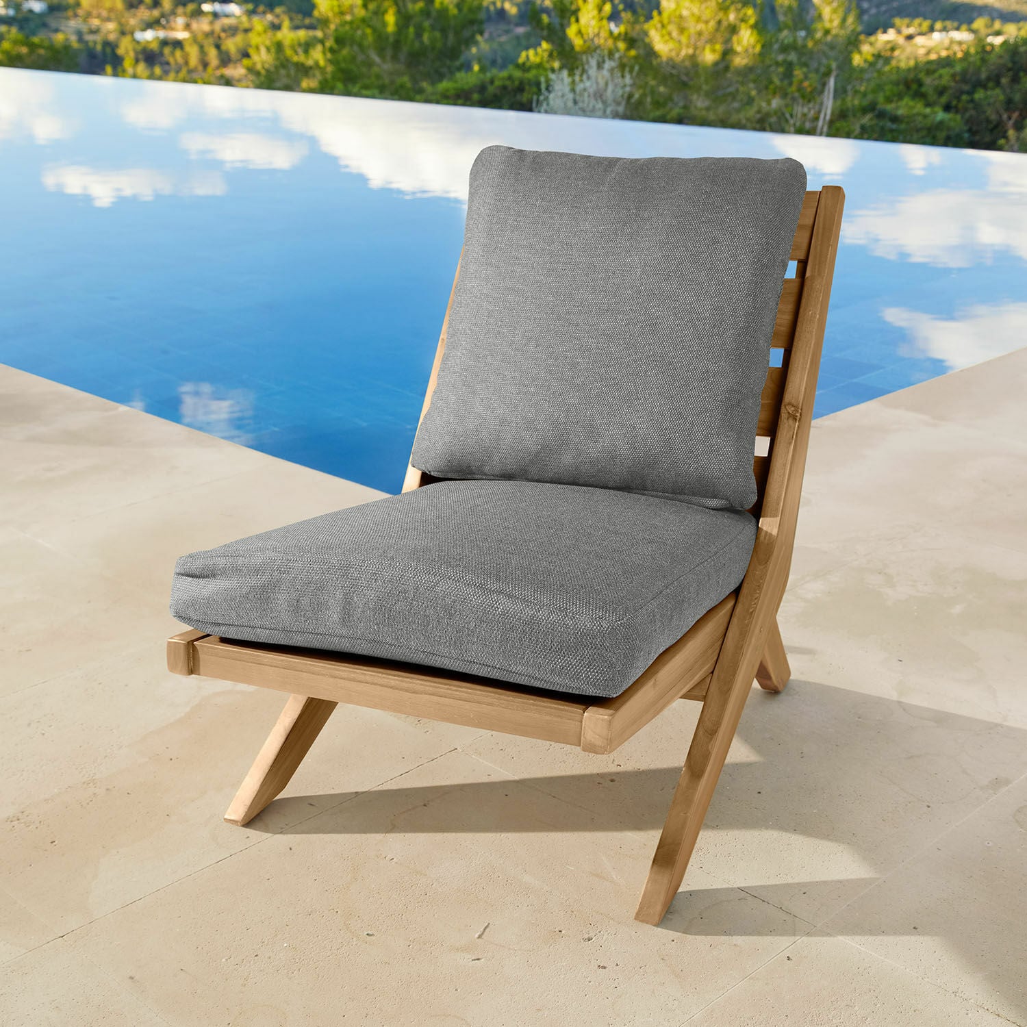 Chaise longue en teck avec coussins gris, parfaite pour se détendre au bord de la piscine
