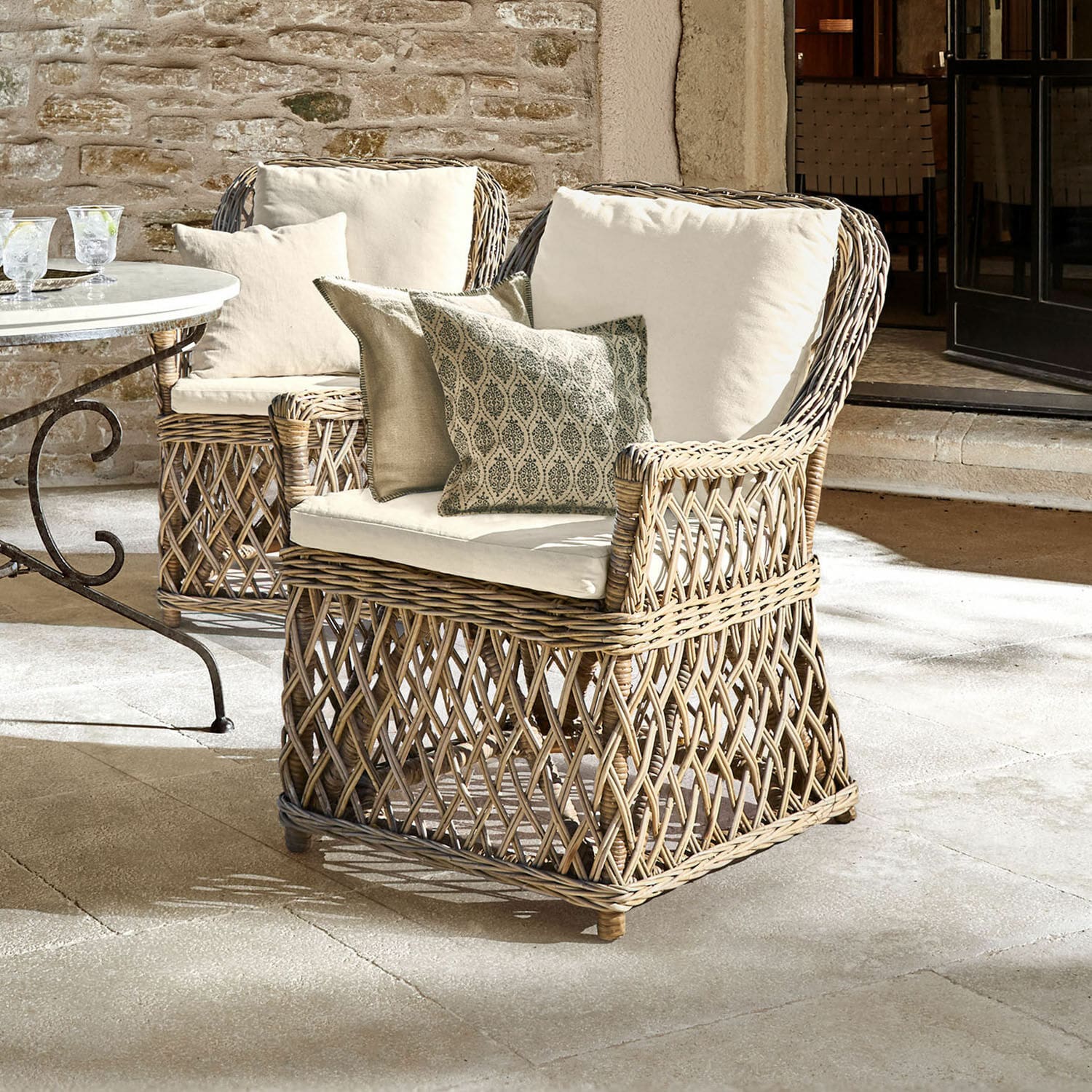 Fauteuil Nesvryn Fauteuil en rotin naturel avec coussins crème et coussins décoratifs pour un confort extérieur élégant.