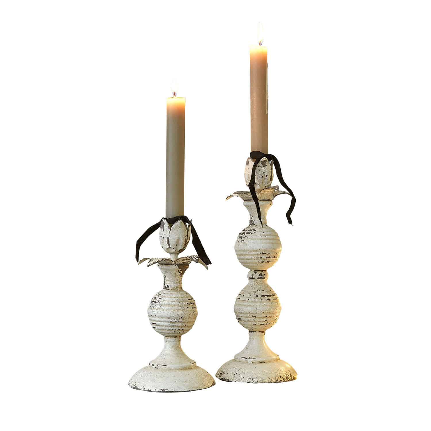 Kaarsenhouder set van 2 Soliras Set van twee witte metalen kandelaars met beige kaarsen en zwarte linten, stijlvolle tafeldecoratie
