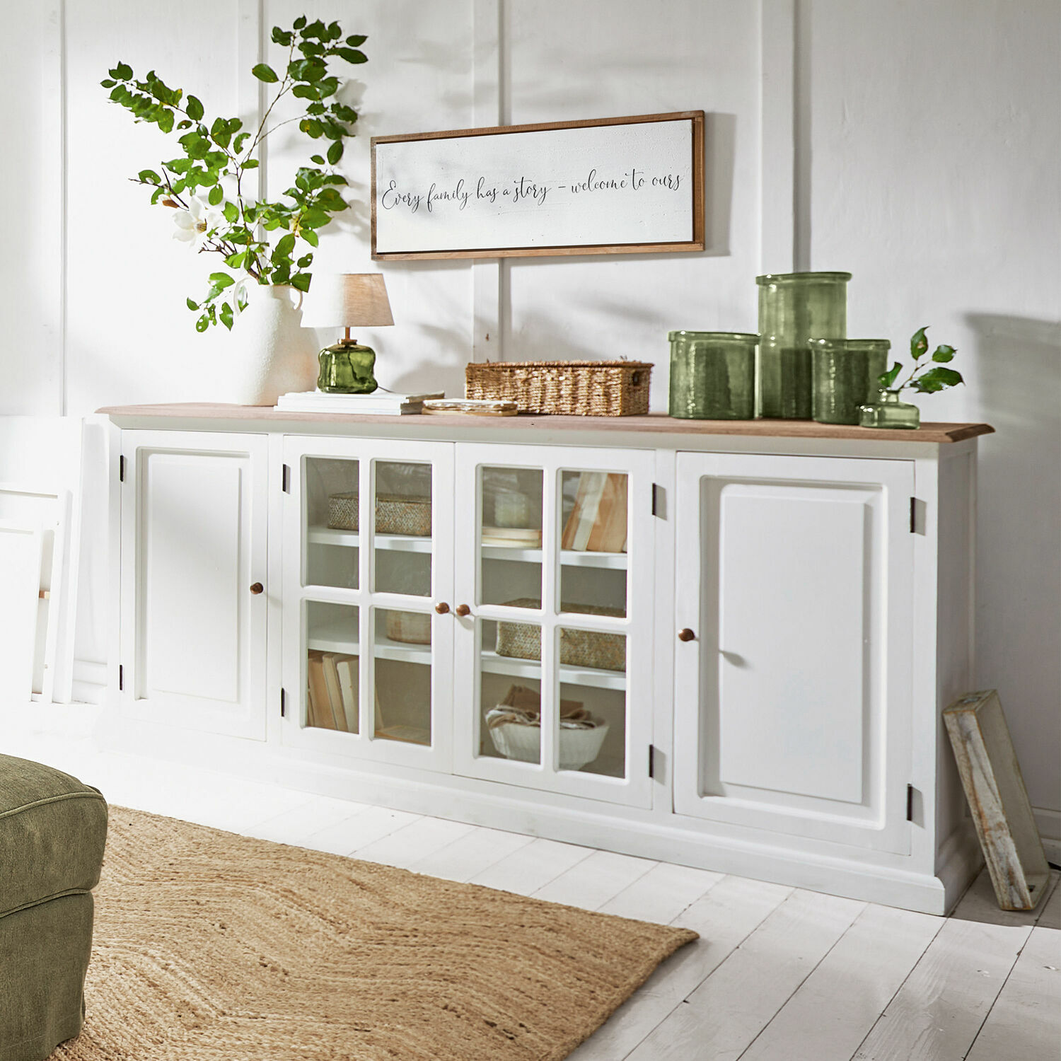 Commode Kostan Buffet en bois blanc avec portes vitrées et plateau en bois clair dans un salon lumineux