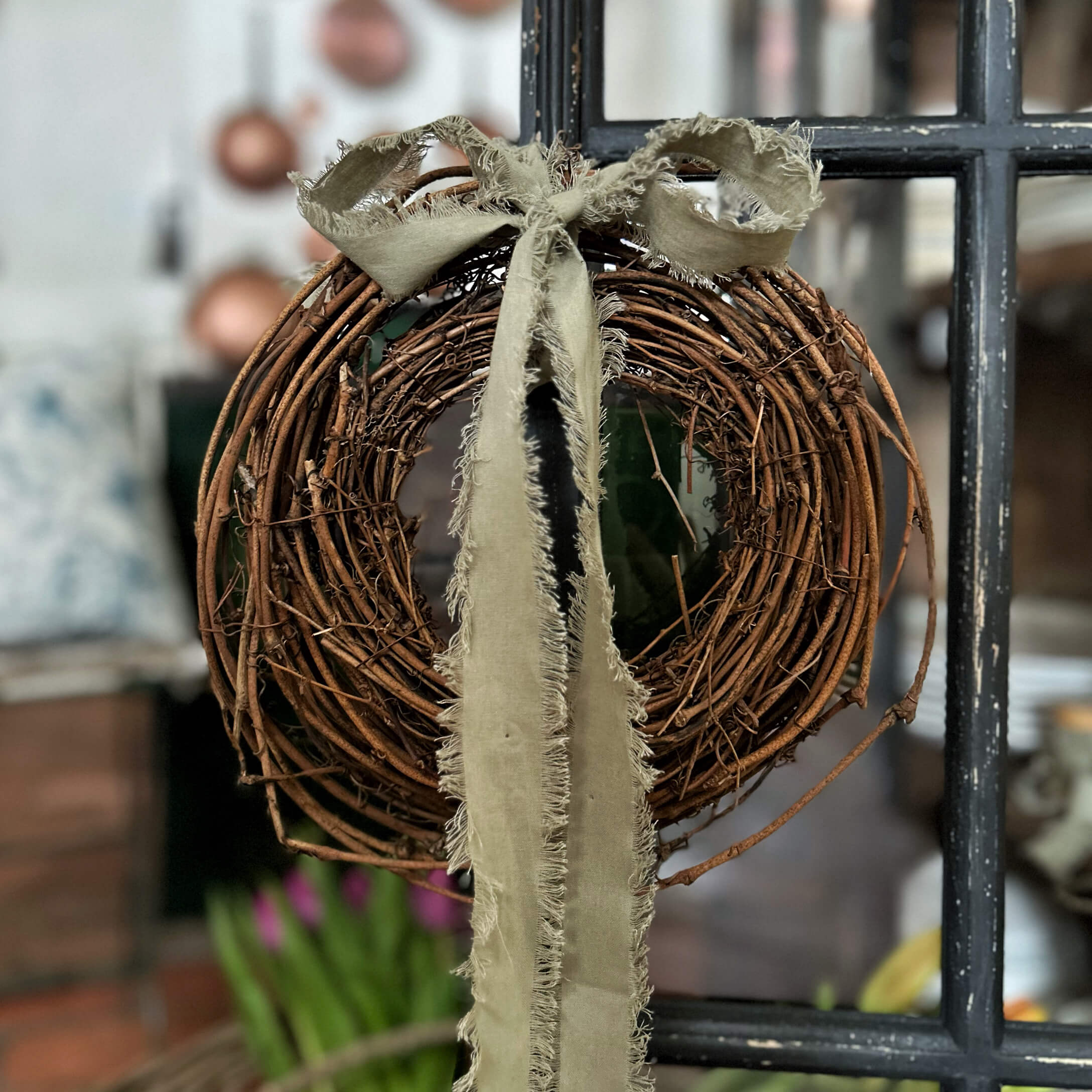 Decoratieve krans van natuurlijke takken met beige rafelige lint voor interieurdecoratie