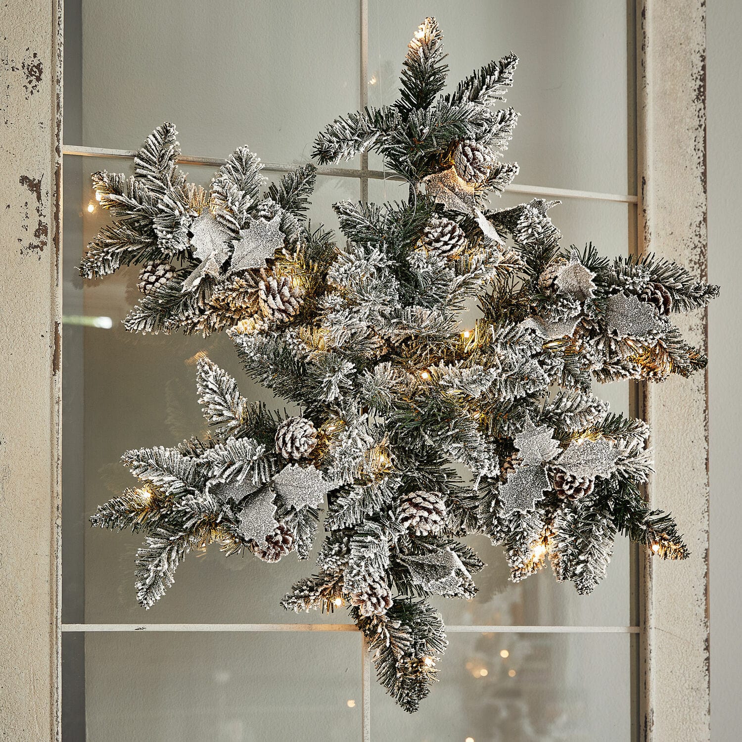 Ledkerststuk Azimara Kerstster van groene takken met dennenappels en sneeuwachtig effect, verlicht met warme LED-lampjes
