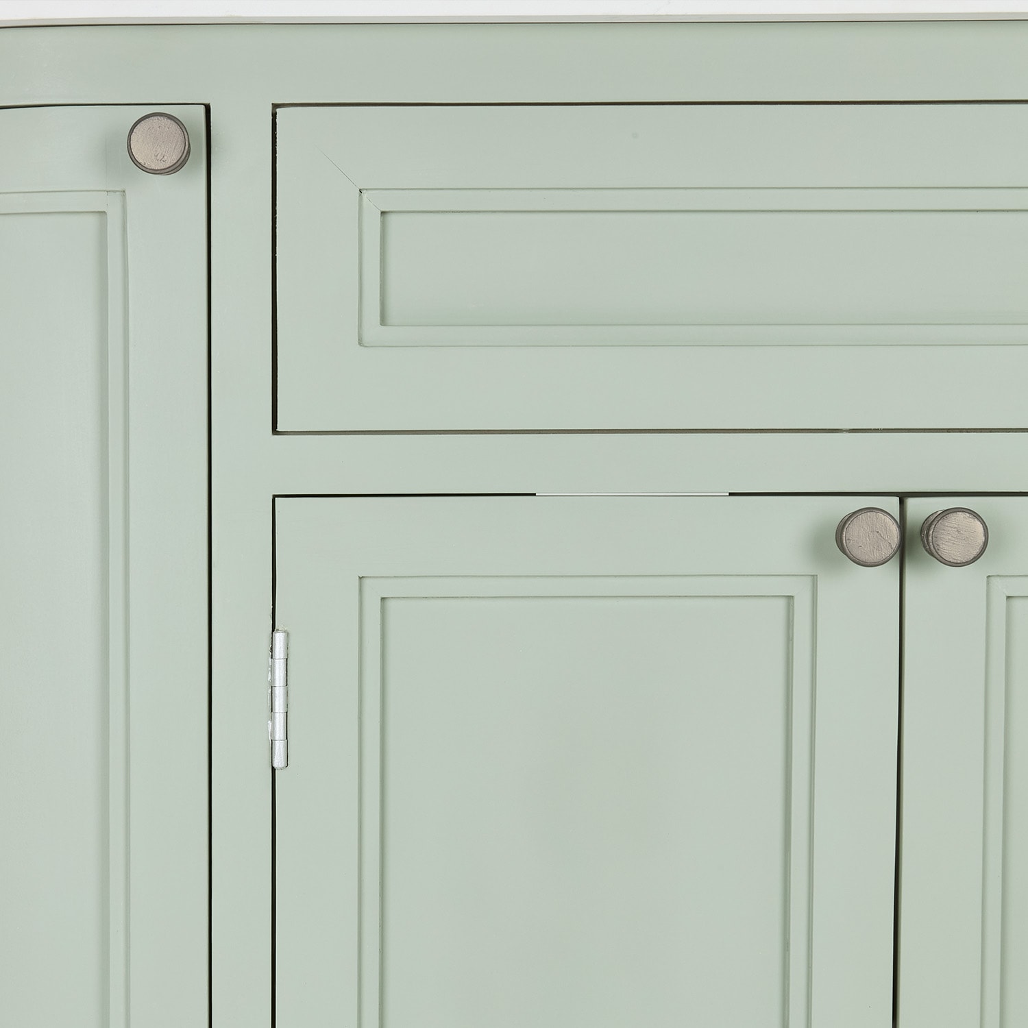Façade d'armoire vert pastel avec poignées en bois et panneaux classiques pour rangement
