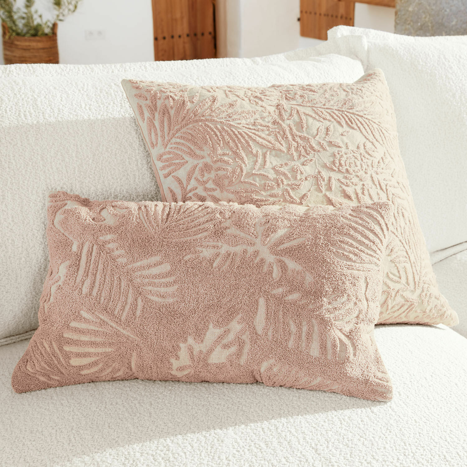 Kussenhoes set van 2 Enchanto Twee decoratieve kussens met roze bladmotief op crèmekleurige achtergrond op witte bank