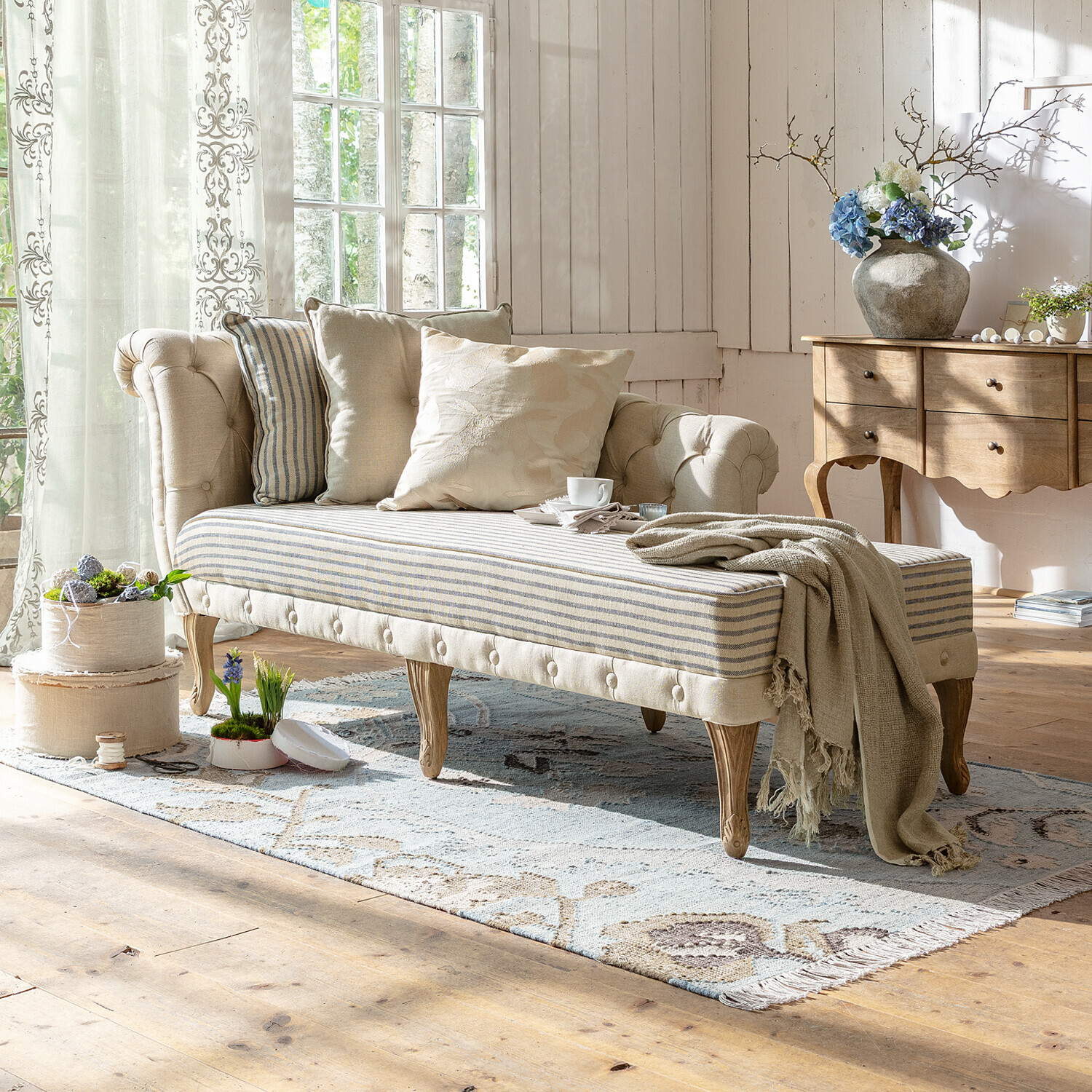 Chaise longue Viviani Beige gestoffeerde chaise longue met houten poten en gestreept zitvlak in lichte woonkamer met kussens