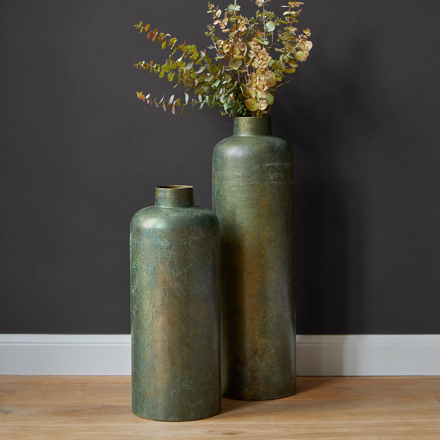 Vaas set van 2 Darwani Twee hoge groene metalen vazen met gedroogde decoratieve bladeren op houten vloer