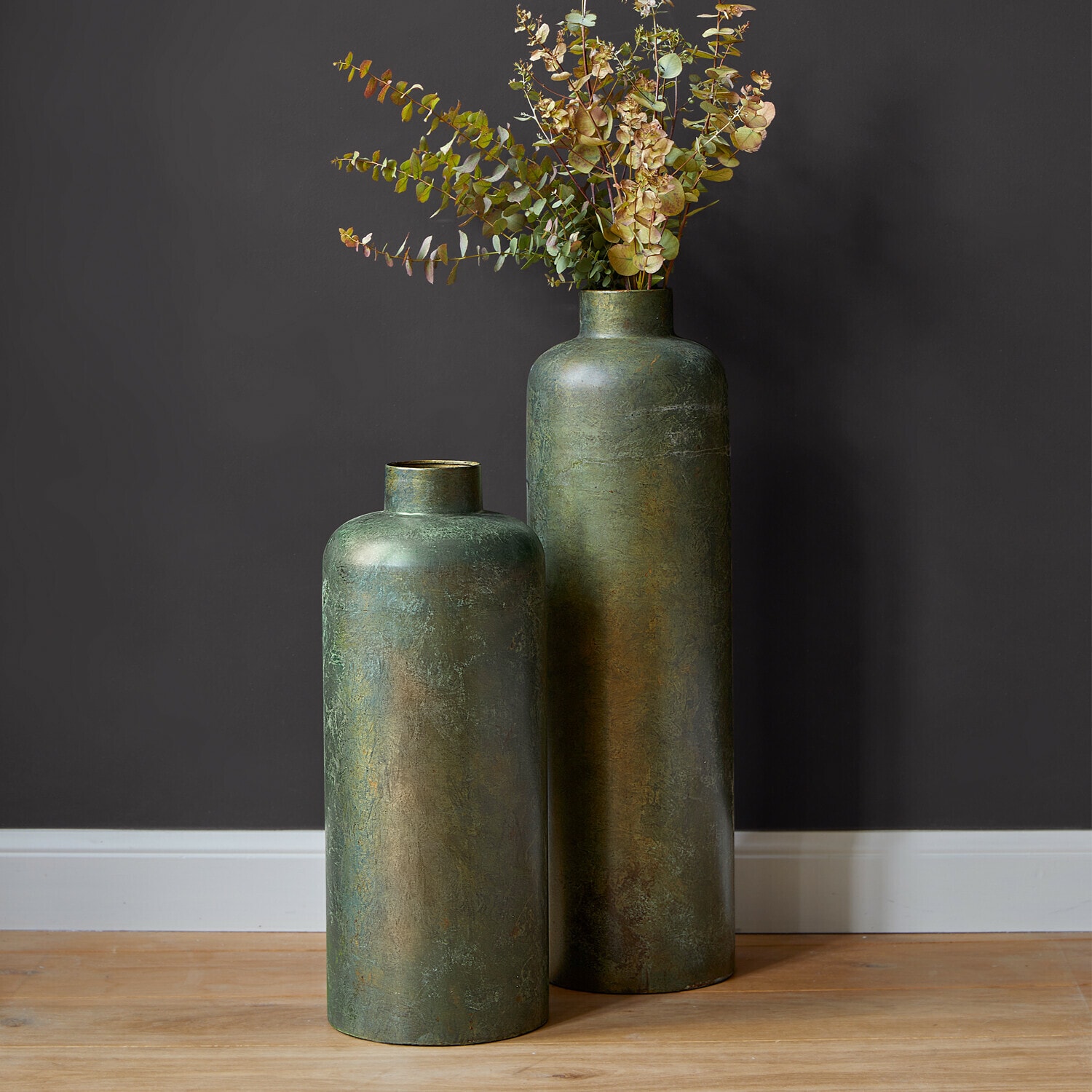 Vaas set van 2 Darwani Twee hoge groene metalen vazen met gedroogde decoratieve bladeren op houten vloer