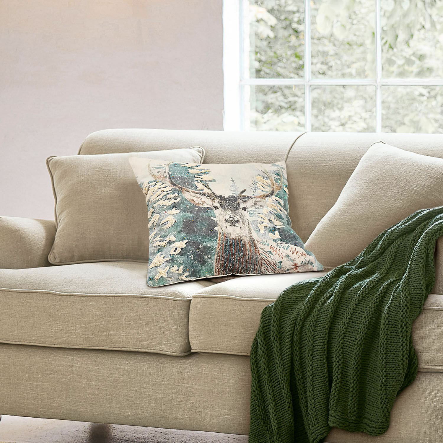 Kussenhoes Elvaris Beige bank met sierkussen met hertmotief en groene gebreide deken in lichte woonkamer
