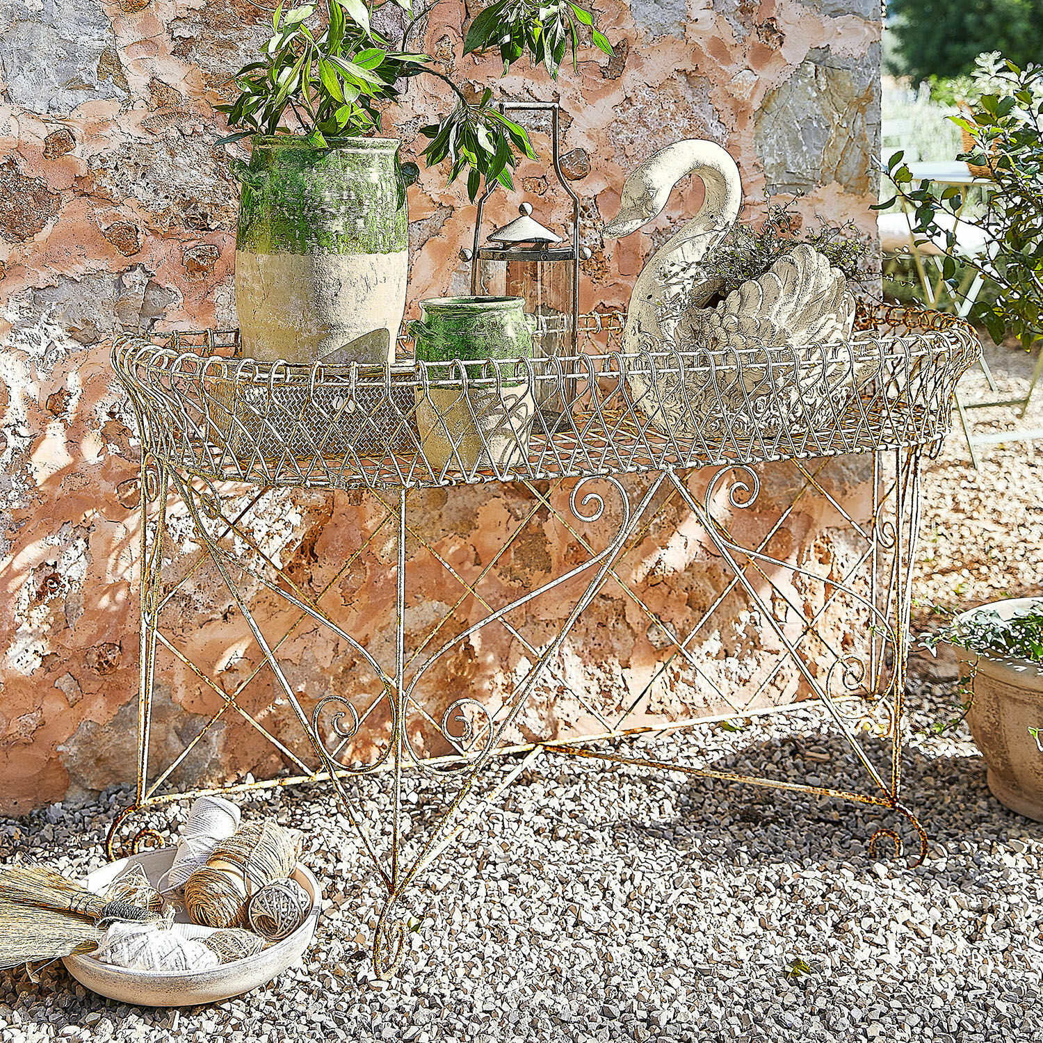 Plantenrek Pacentro Rustieke metalen tuintafel met decoratieve potten en zwaanornament voor stenen muur