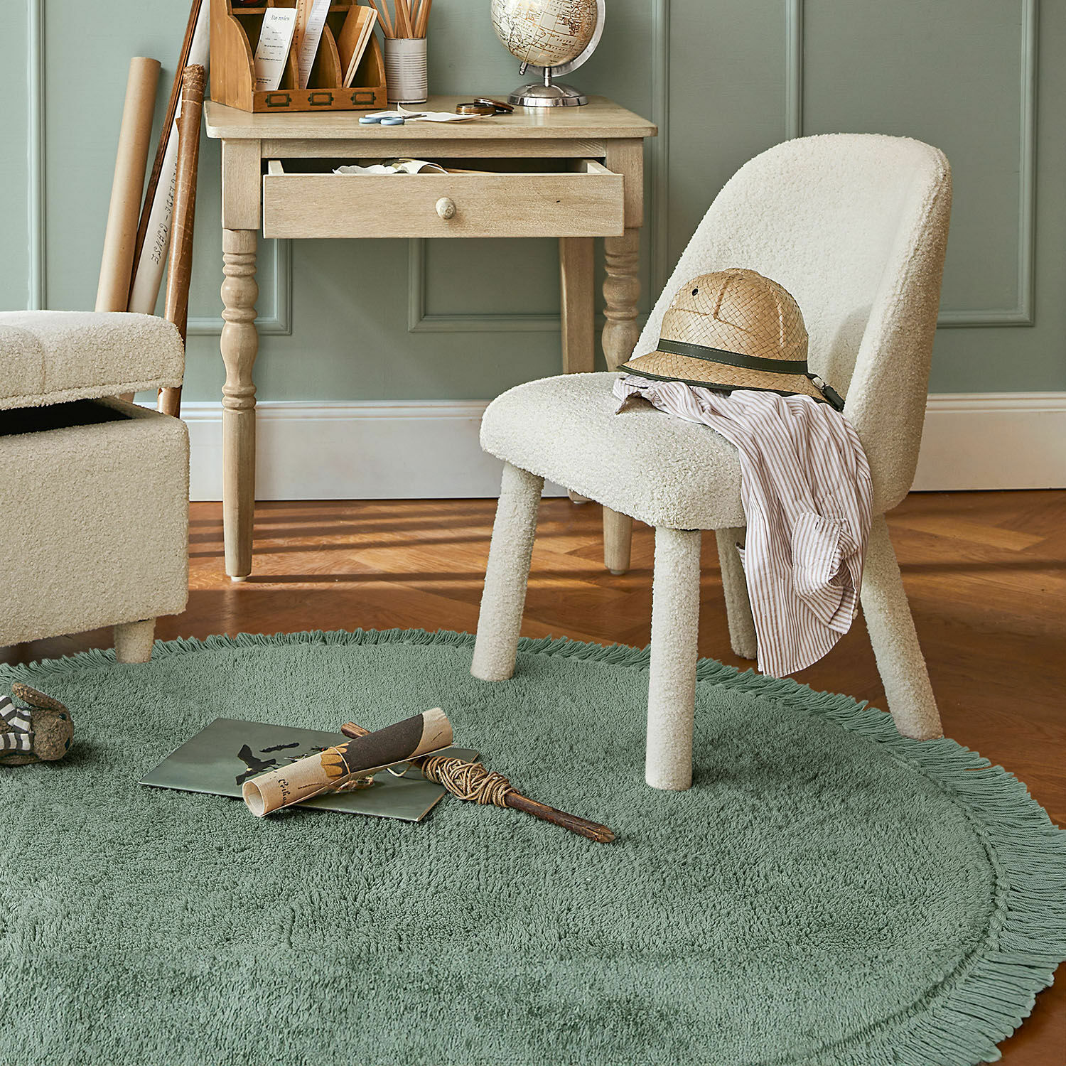 Vloerkleed Ivalex Crèmekleurige gestoffeerde stoel op groene ronde vloerkleed met franjes in kamer met houten bureau