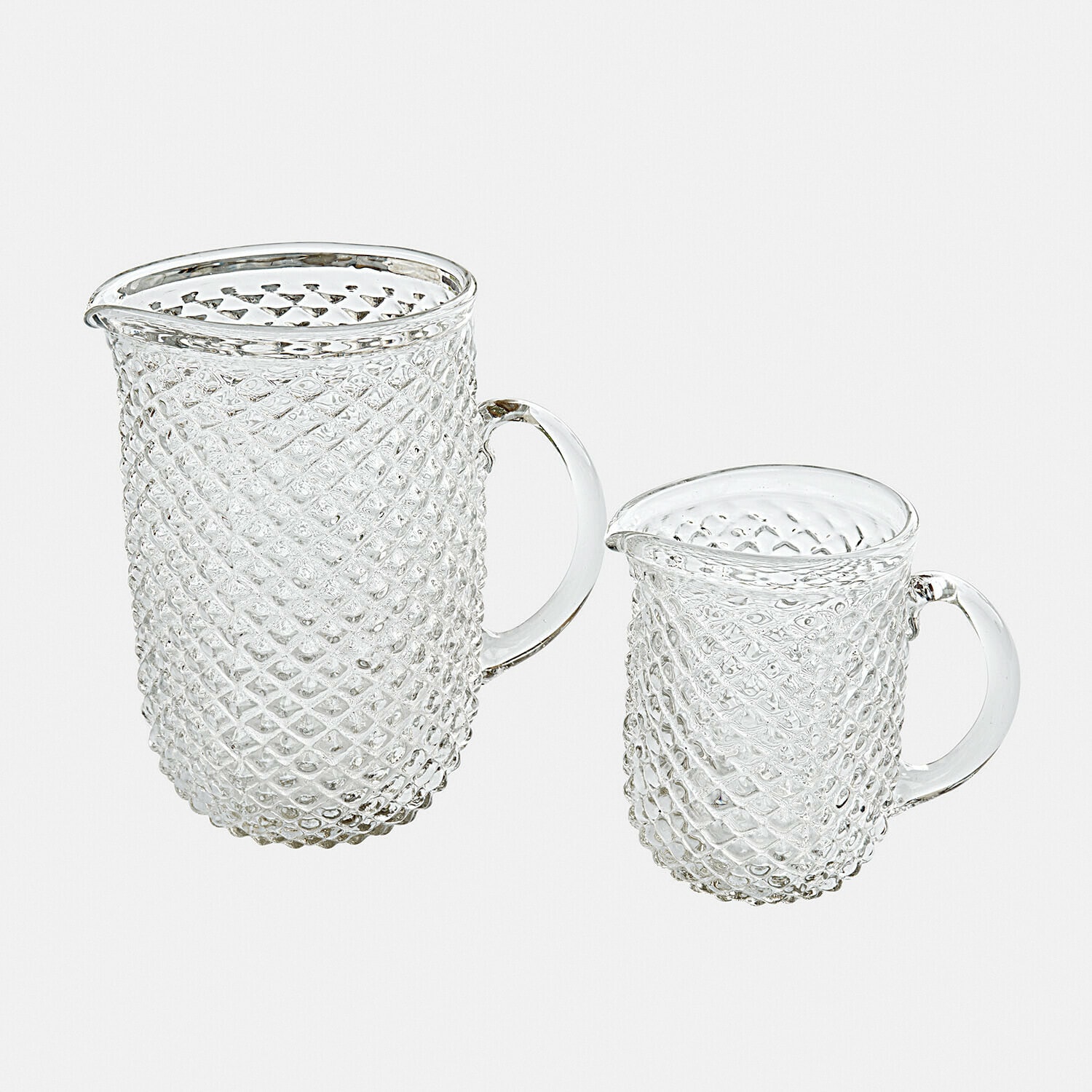 Lot de 2 pichets Ivorias Ensemble de deux pichets en verre transparent à motif diamanté pour servir des boissons