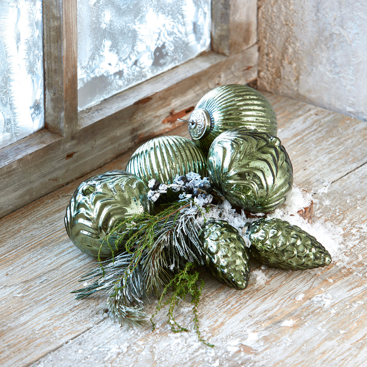 Lot de 6 décorations de Noël Silverhill Boules de Noël vertes en verre avec différentes textures, branches et fausse neige sur un rebord en bois