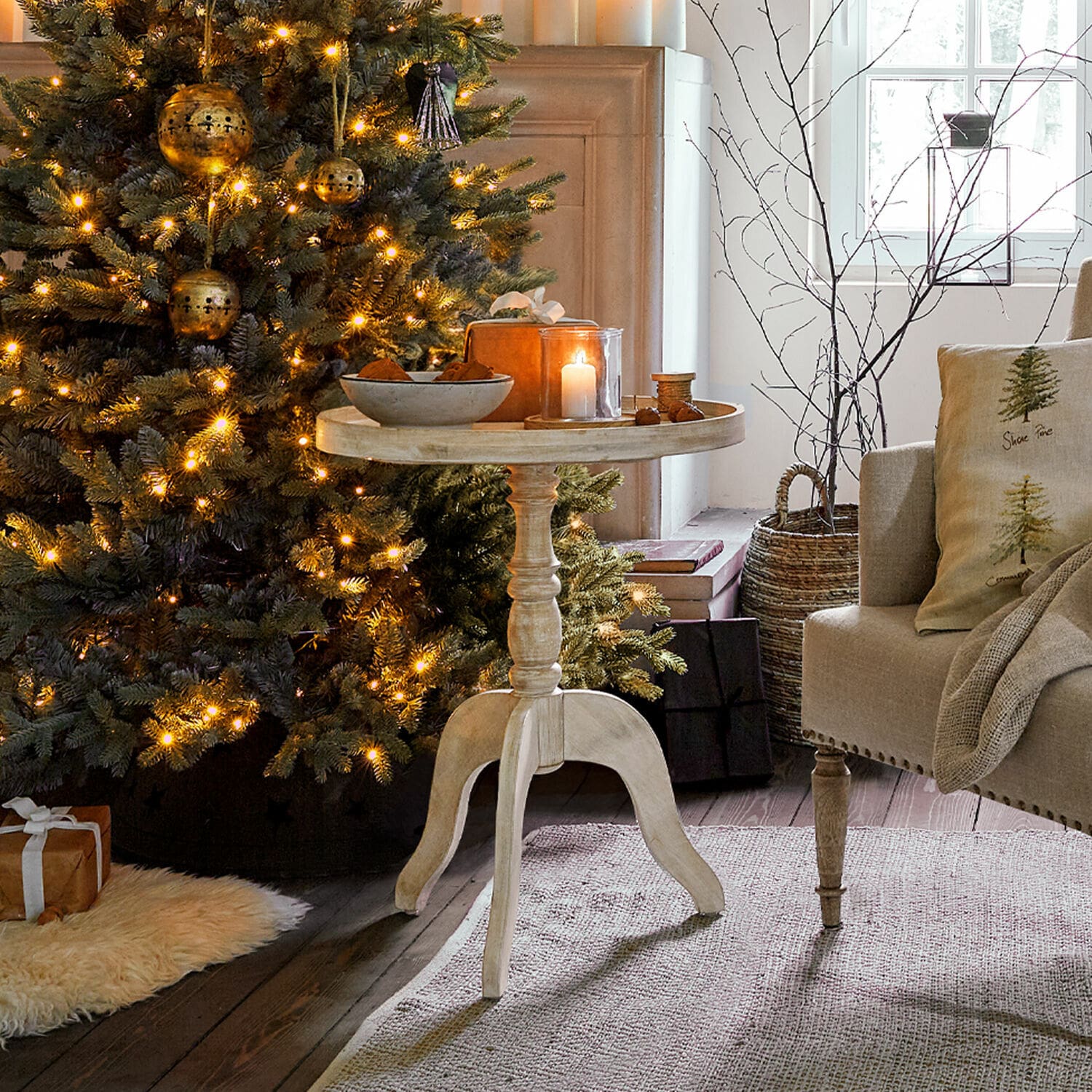 Bijzettafel Brookdale Ronde lichte houten bijzettafel naast sfeervol verlichte kerstboom in gezellige woonkamer