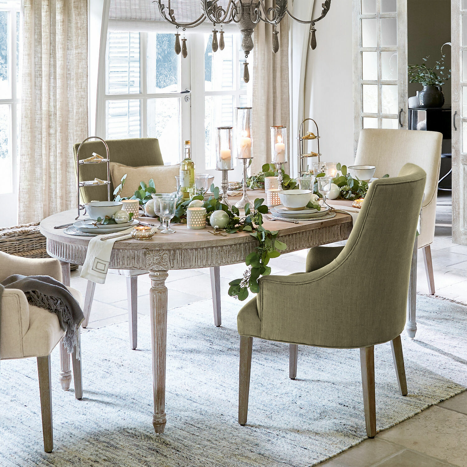 Tafel Cienegas Eetkamer met ovale houten tafel en groene en beige gestoffeerde stoelen, feestelijke decoratie