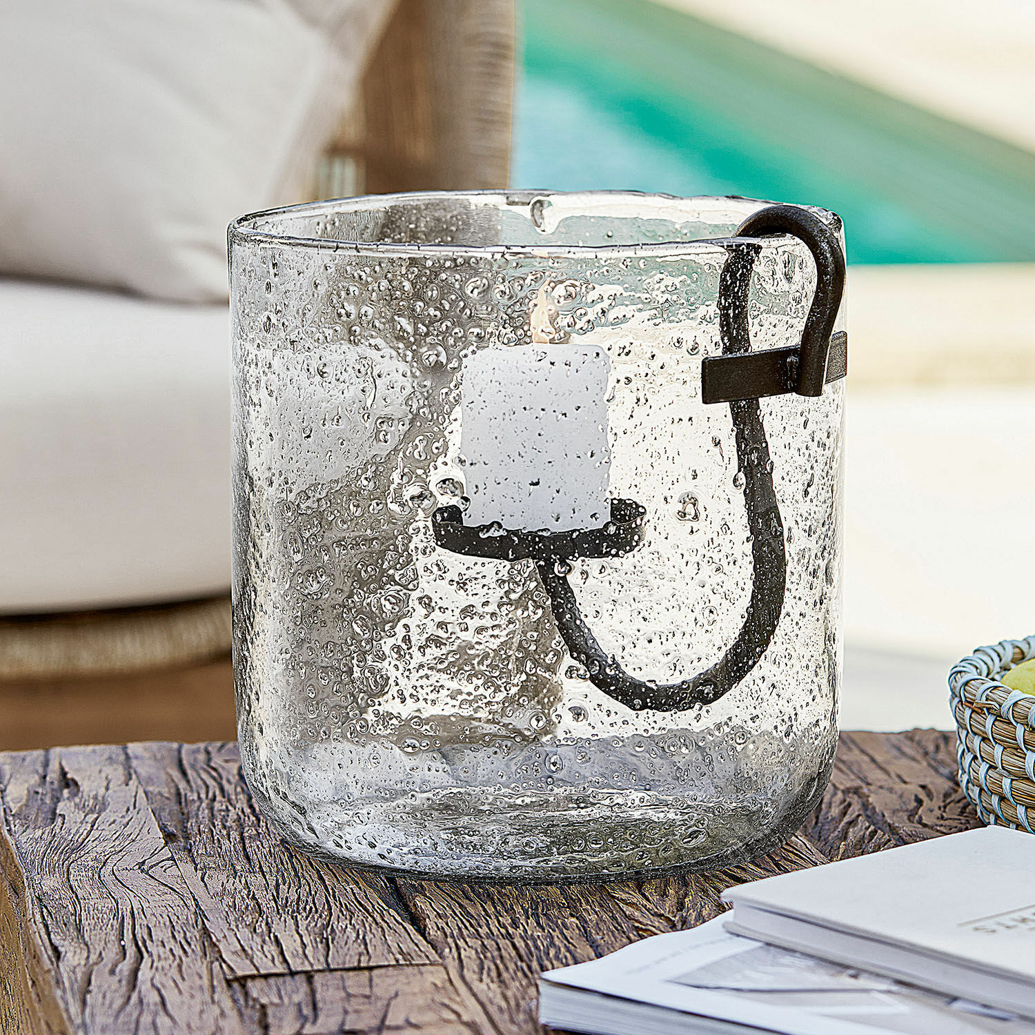 Windlicht Dions Glazen windlicht met bubbels en zwart metalen handvat op rustieke houten tafel