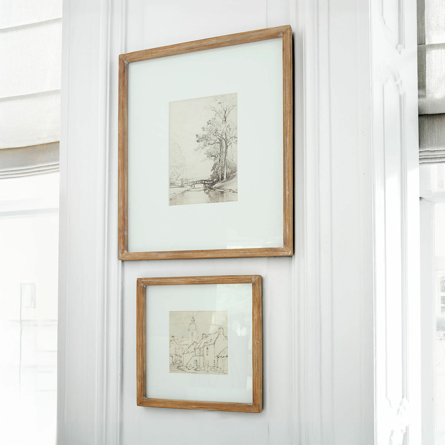Lot de 2 tableaux Juvarel Deux cadres en bois rustique avec dessins de paysages accrochés sur un mur blanc lumineux