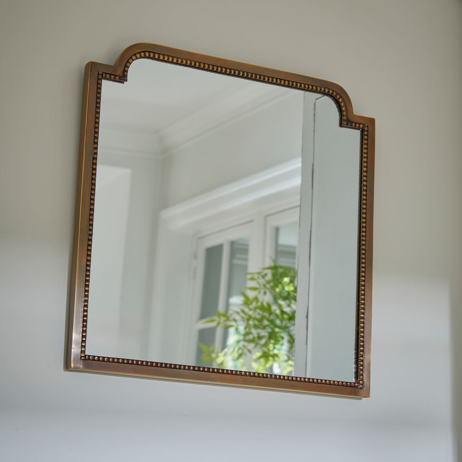 Miroir mural avec cadre en laiton orné, parfait pour la décoration intérieure élégante