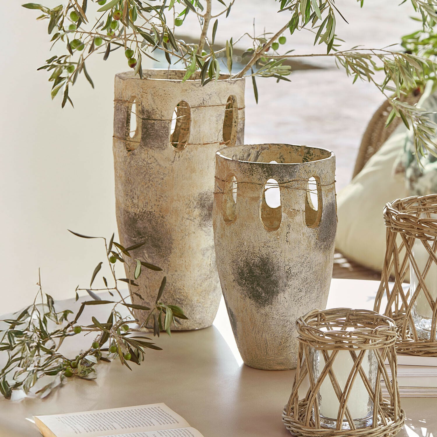 Vaas set van 2 Delunas Twee decoratieve vazen van steen in beige-grijs met openingen en olijftakken op een tafel