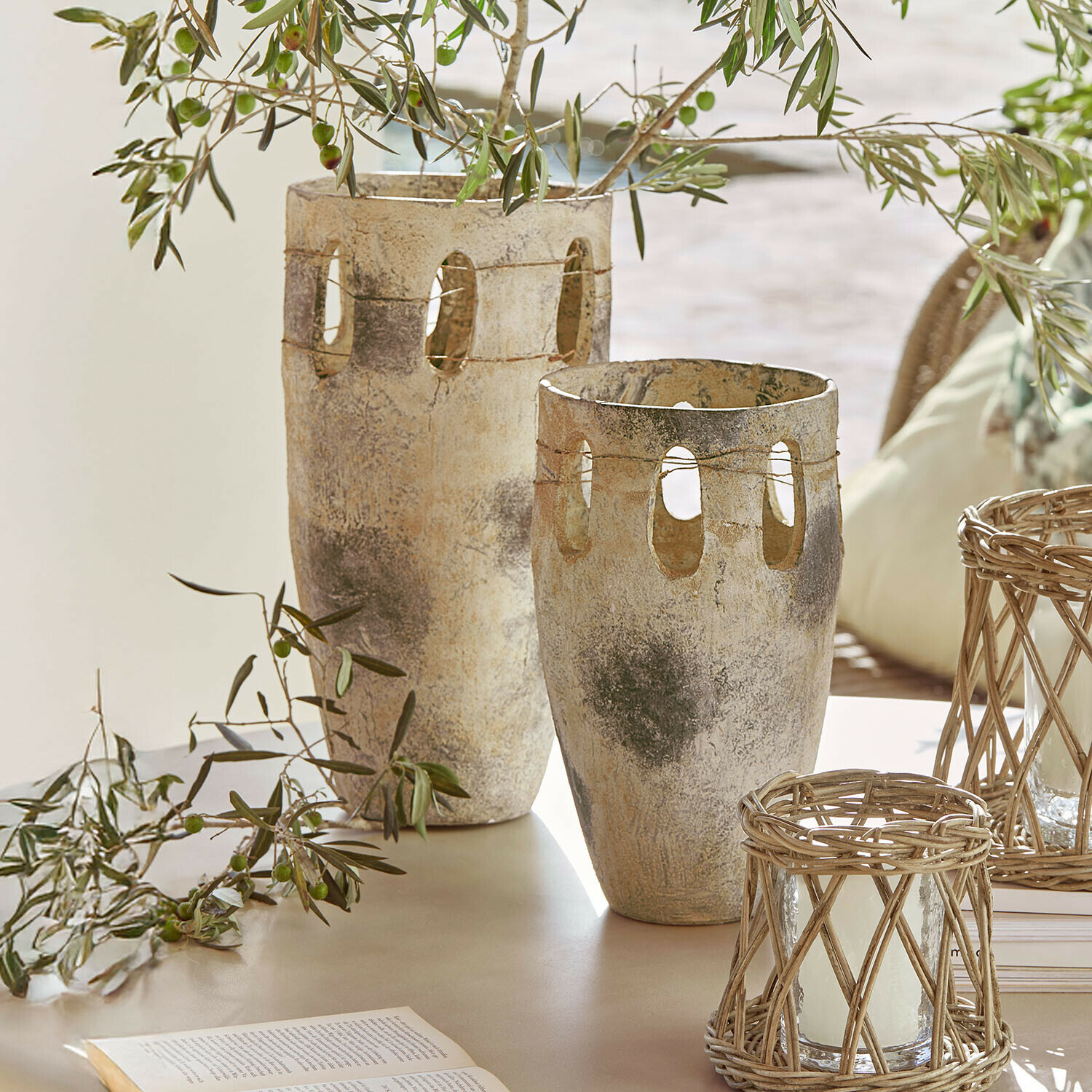 Vaas set van 2 Delunas Twee decoratieve vazen van steen in beige-grijs met openingen en olijftakken op een tafel