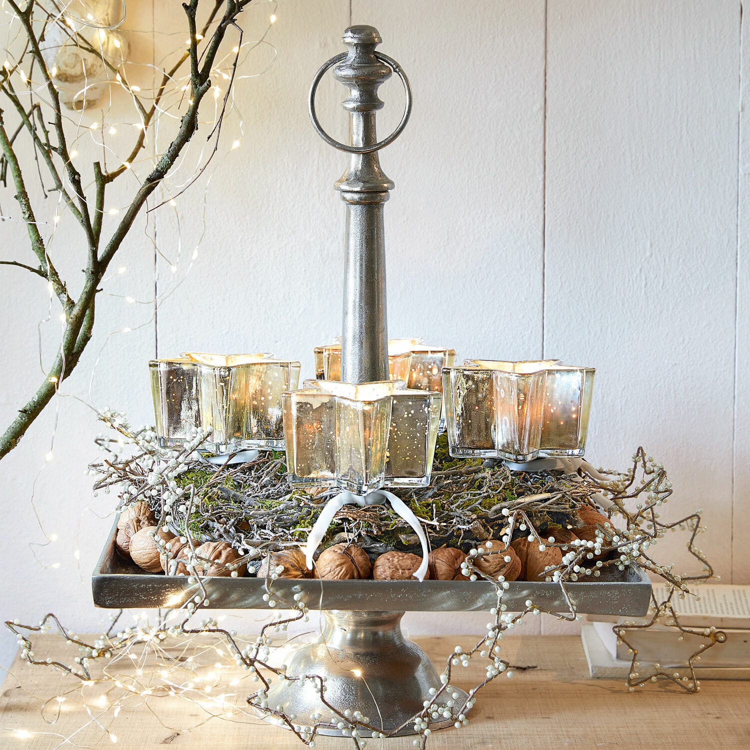 Metalen kandelaar met vier glazen stervormige theelichthouders, versierd met noten en takken