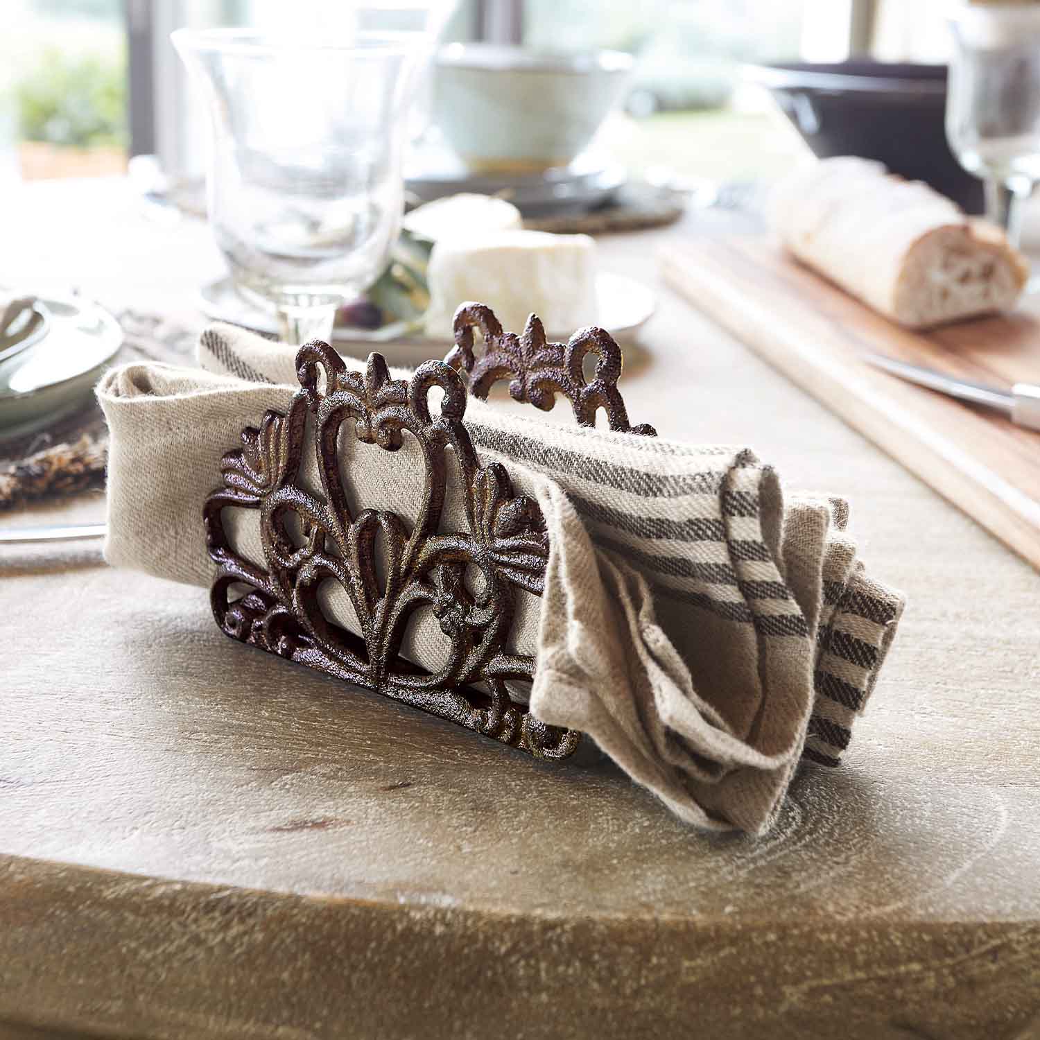 Rustieke metalen servethouder met decoratief patroon en linnen servet op tafel