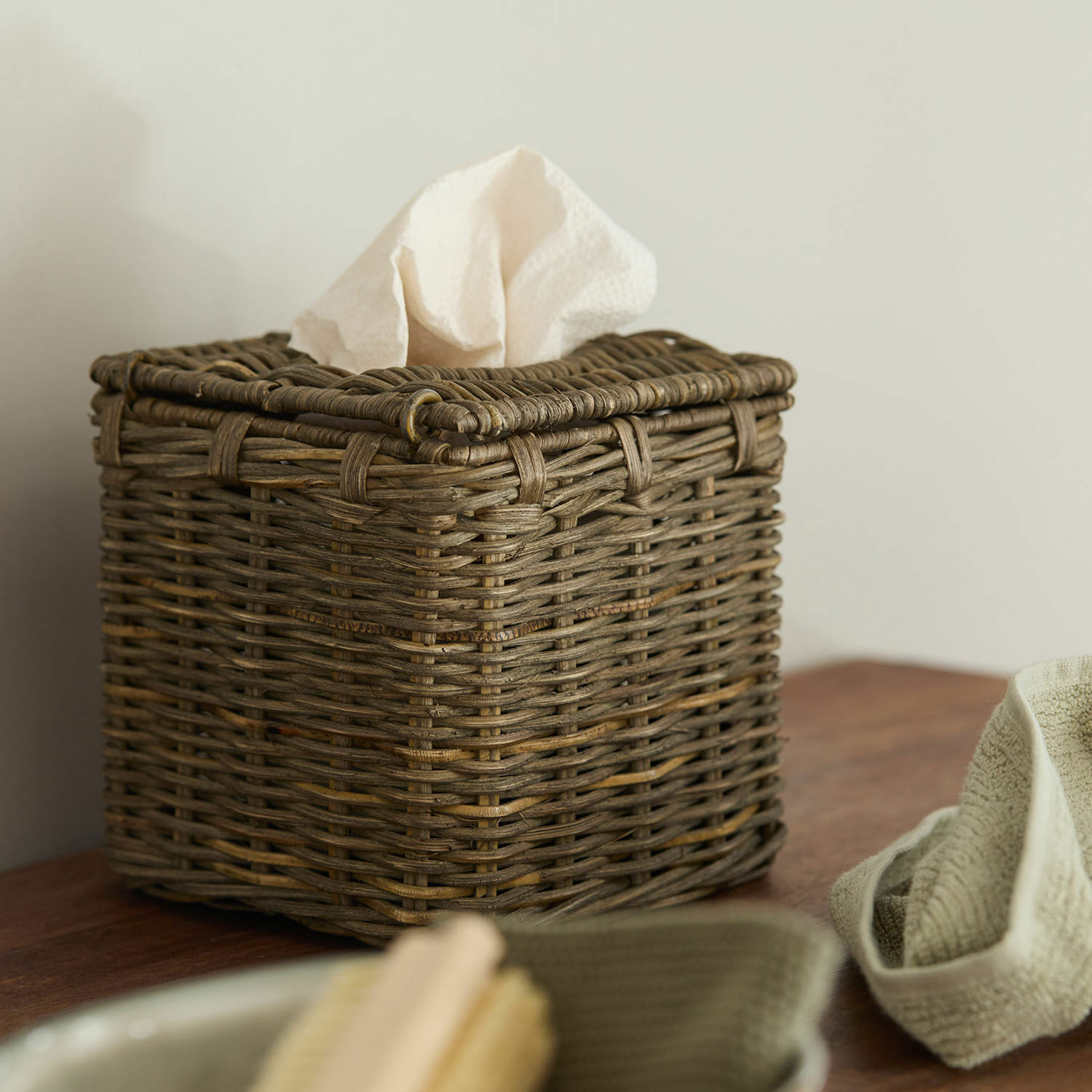 Boîte à mouchoirs Livry Boîte à mouchoirs carrée en osier marron posée sur une table en bois
