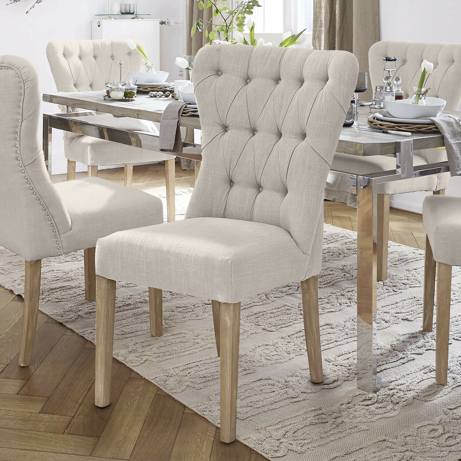 Chaise Saint-Laurent Chaises rembourrées beige avec pieds en bois autour d'une table en bois clair dans une salle à manger