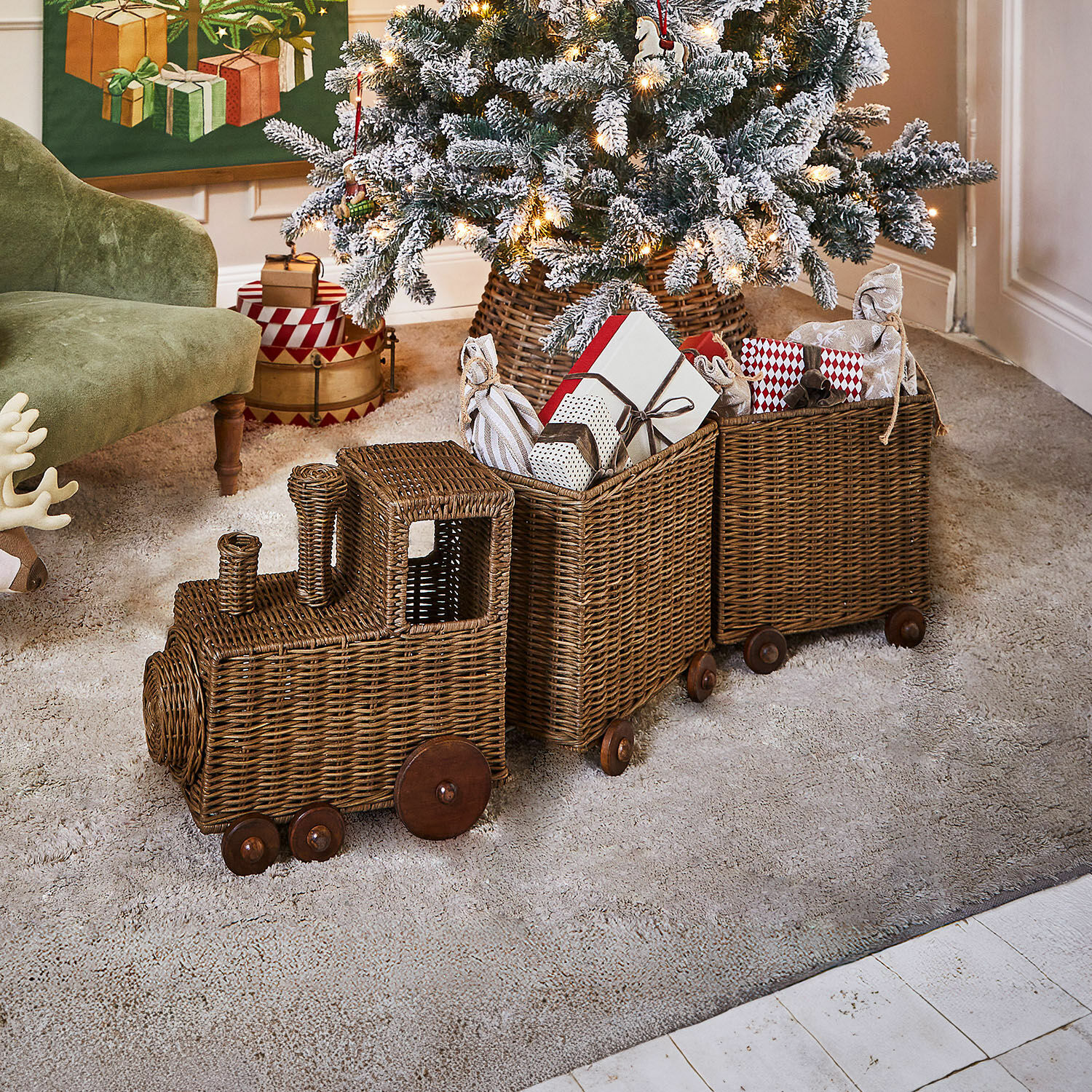 Train décoratif Kareeva Train décoratif en osier marron avec roues en bois, rempli de cadeaux de Noël dans un salon festif
