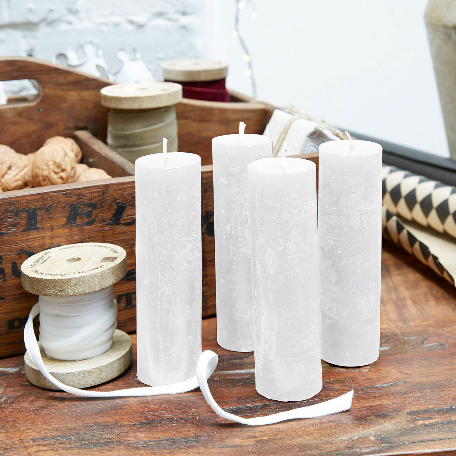 Kaars set van 4 Muriel Set van vier witte kaarsen van natuurlijke was op houten tafel met decoraties