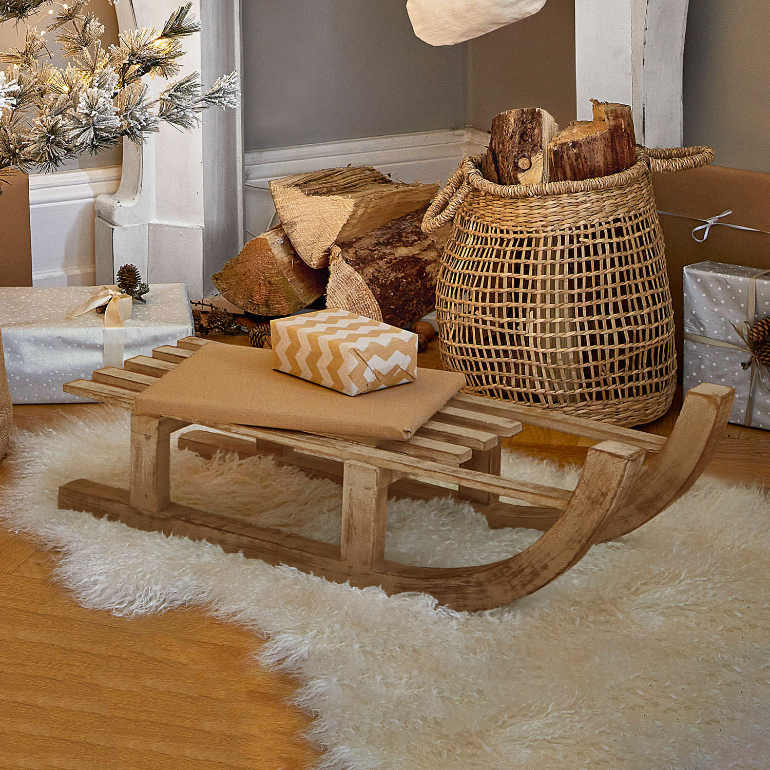 Sierslee FSC®-100% Hoekstra Decoratieve houten slee op witte schapenvacht met cadeaus en mand met houtblokken
