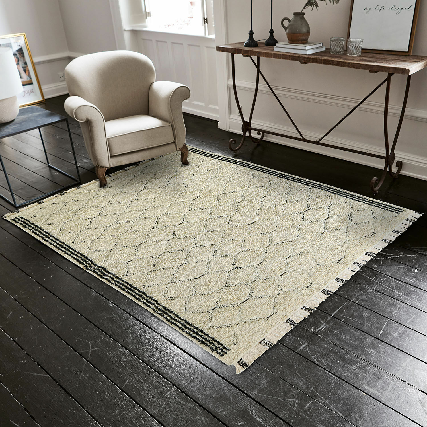 Vloerkleed Himesto Beige vloerkleed met geometrisch patroon en franjes op donkere houten vloer in woonkamer