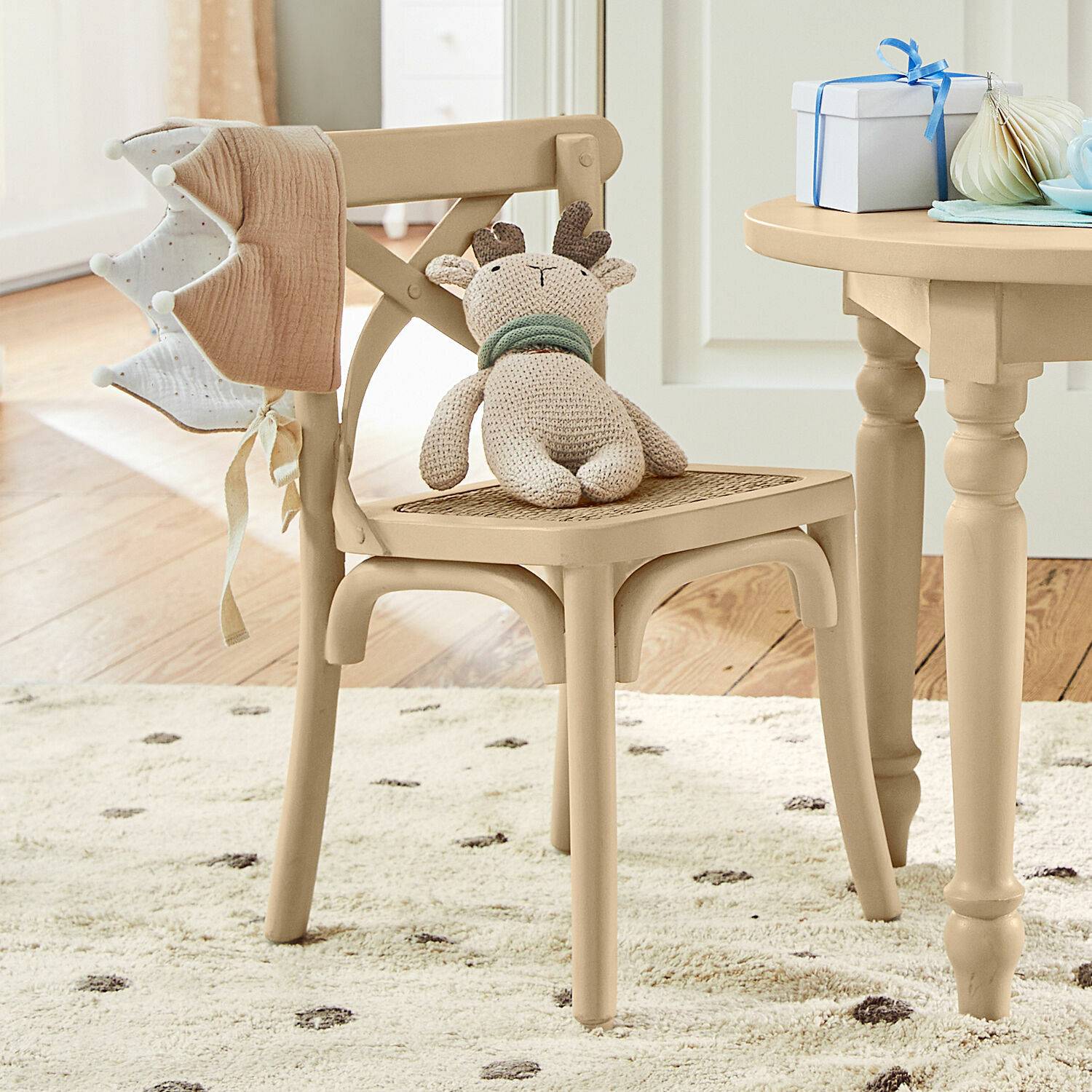 Kinderstoel Sourila Beige houten stoel met gevlochten zitting en gebreide rendierknuffel in kinderkamer