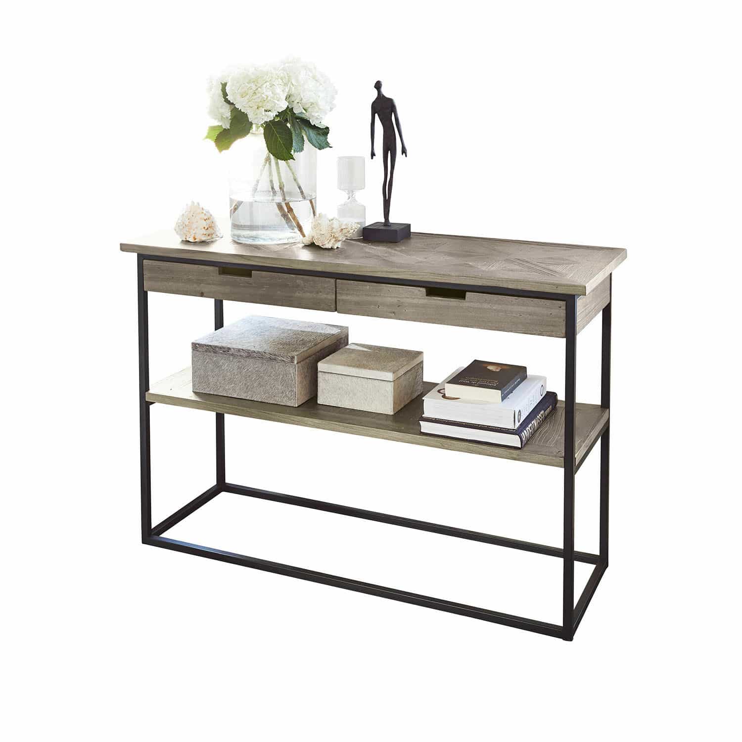 Console en bois gris et métal avec tiroirs et étagère, décorée de livres et fleurs blanches