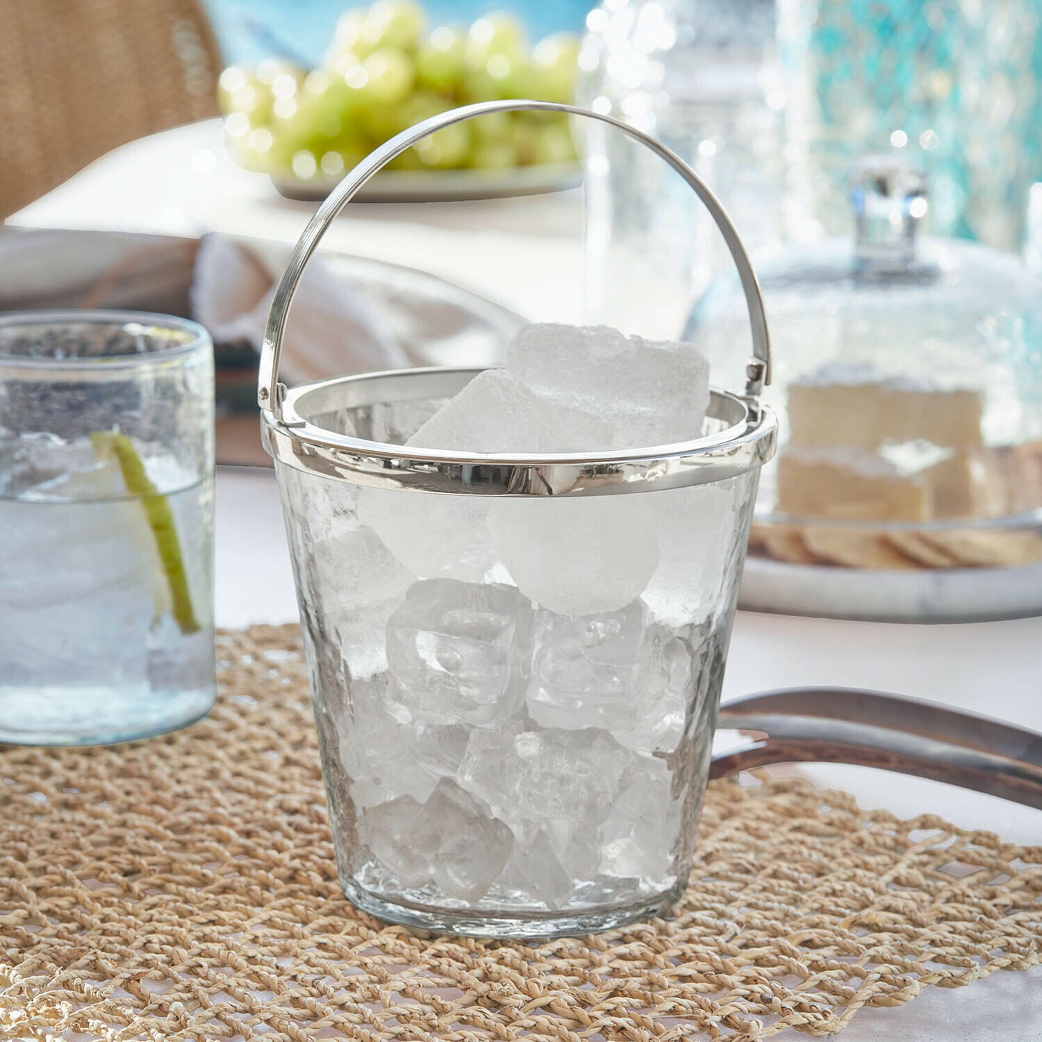 Seau à glaçons Cressford Seau à glace en verre avec poignée en métal sur table, parfait pour servir des boissons fraîches