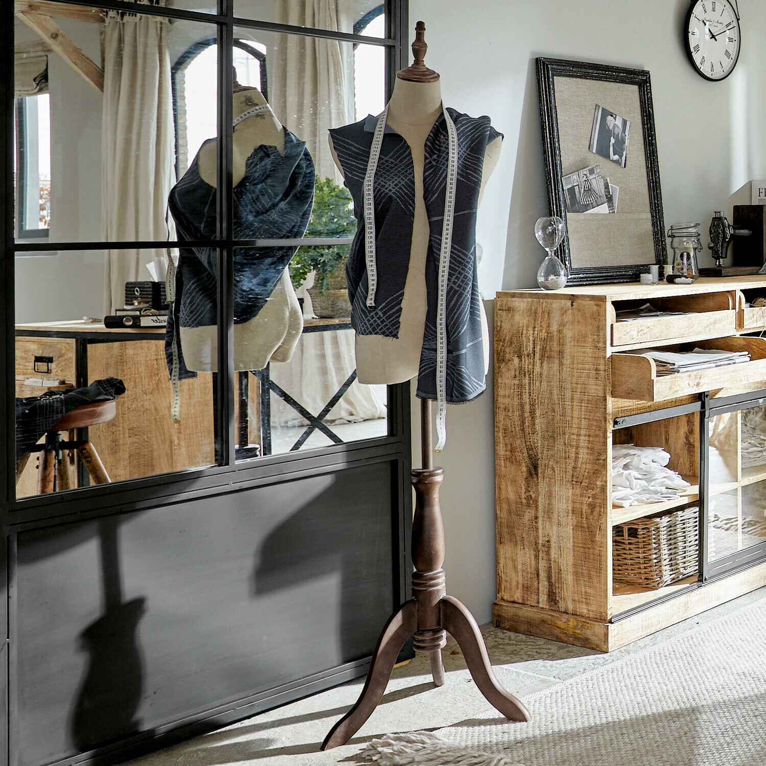 Buste Sneider Kledingpaspop met donkere stof en houten standaard in lichte kamer met houten dressoir