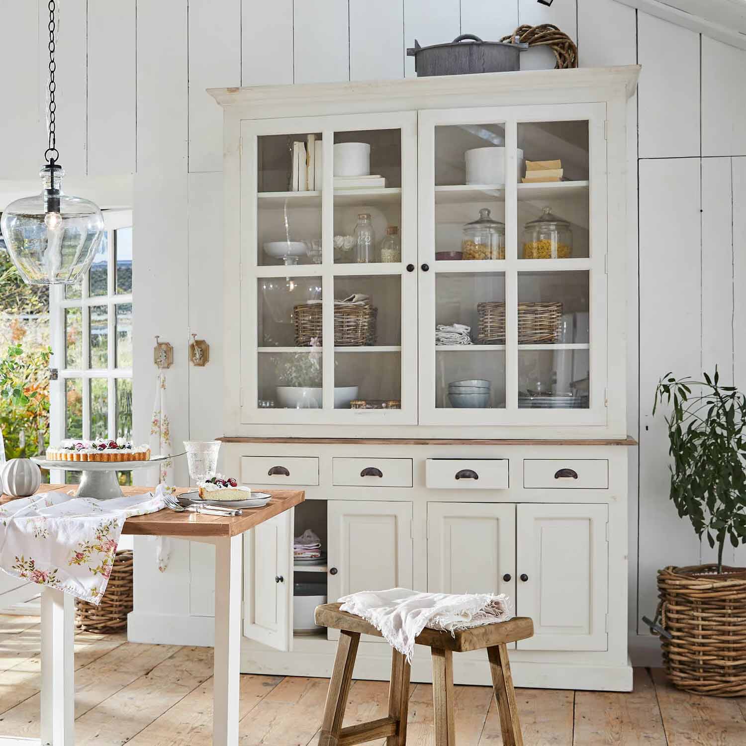 Vaisselier en bois blanc avec portes vitrées et tiroirs dans une cuisine au style rustique