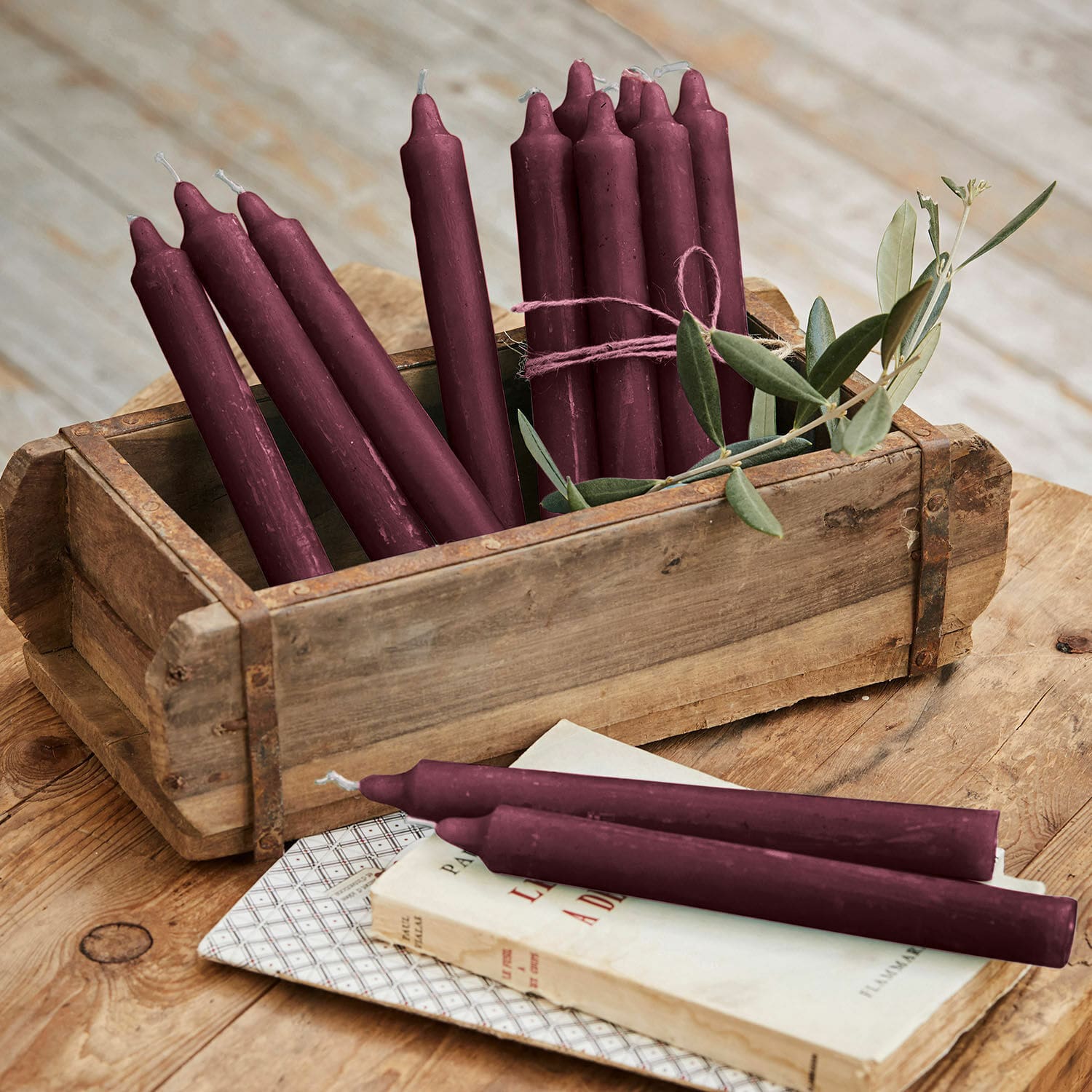 Lot de 12 bougies Bauceau Lot de bougies bordeaux en cire dans une boîte en bois sur une table rustique