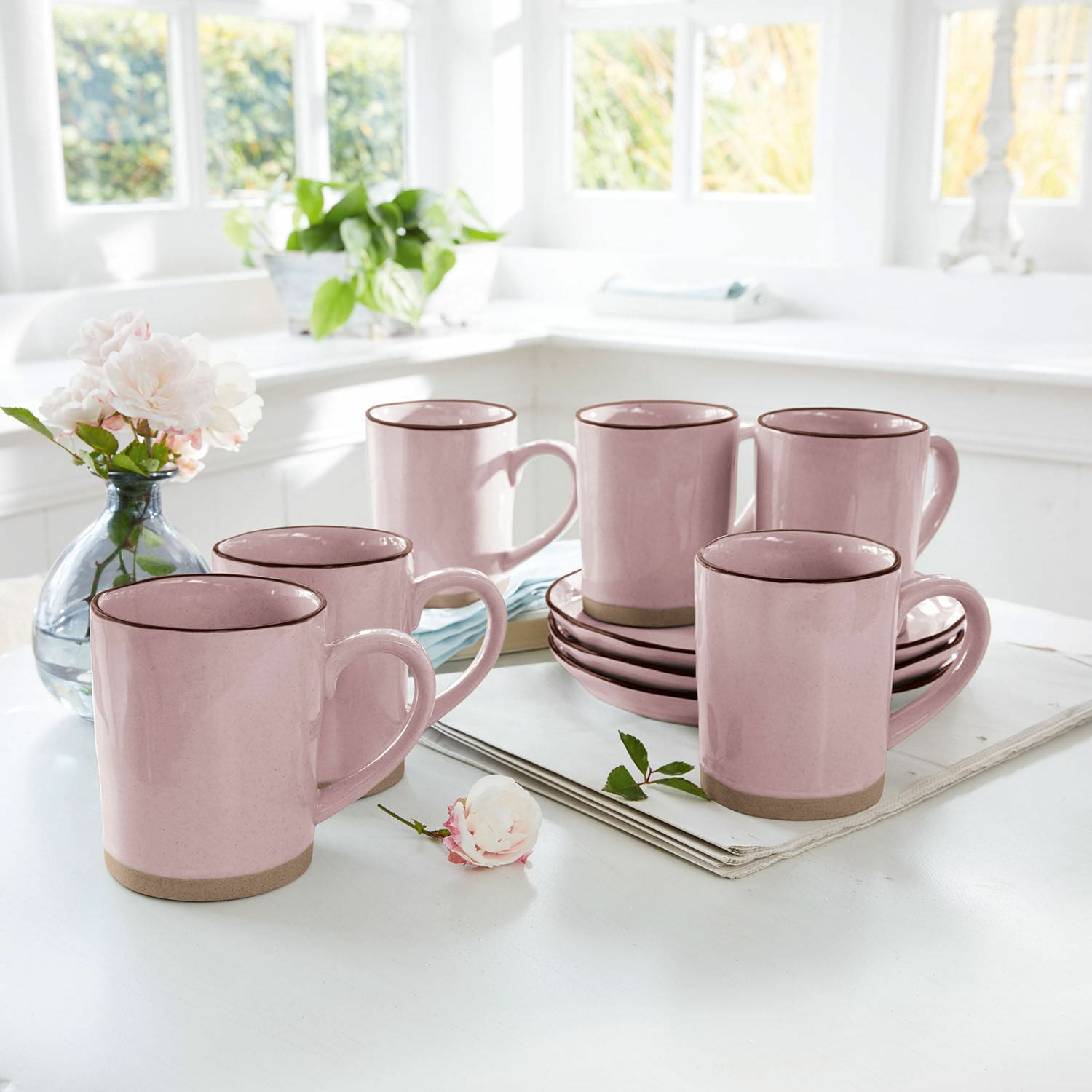 Mok set van 6 Biarré Set roze keramische mokken met bruine rand en schotels op lichte keukentafel